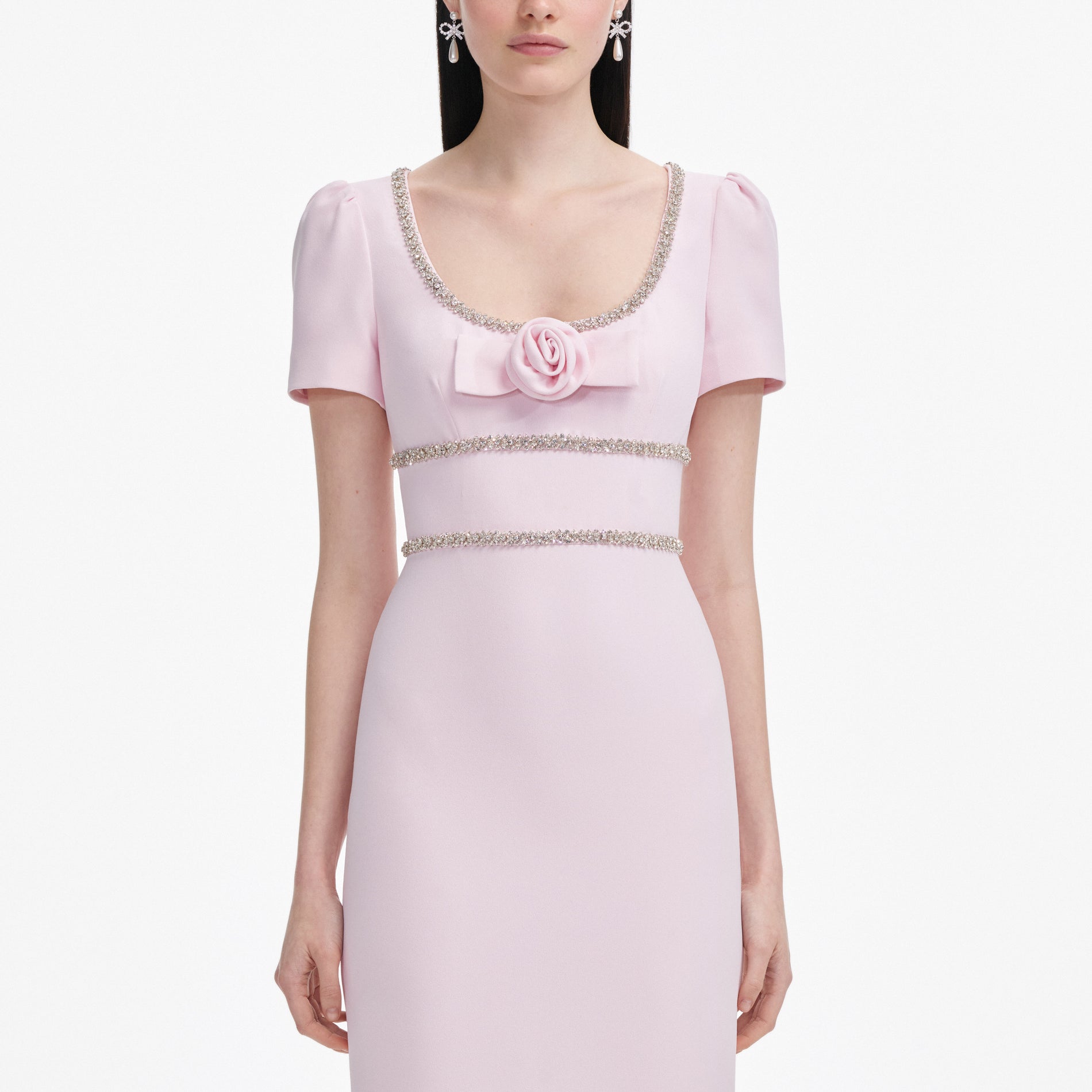 A close up of a woman wearing the Pink Crepe Crystal Trim Maxi Dress