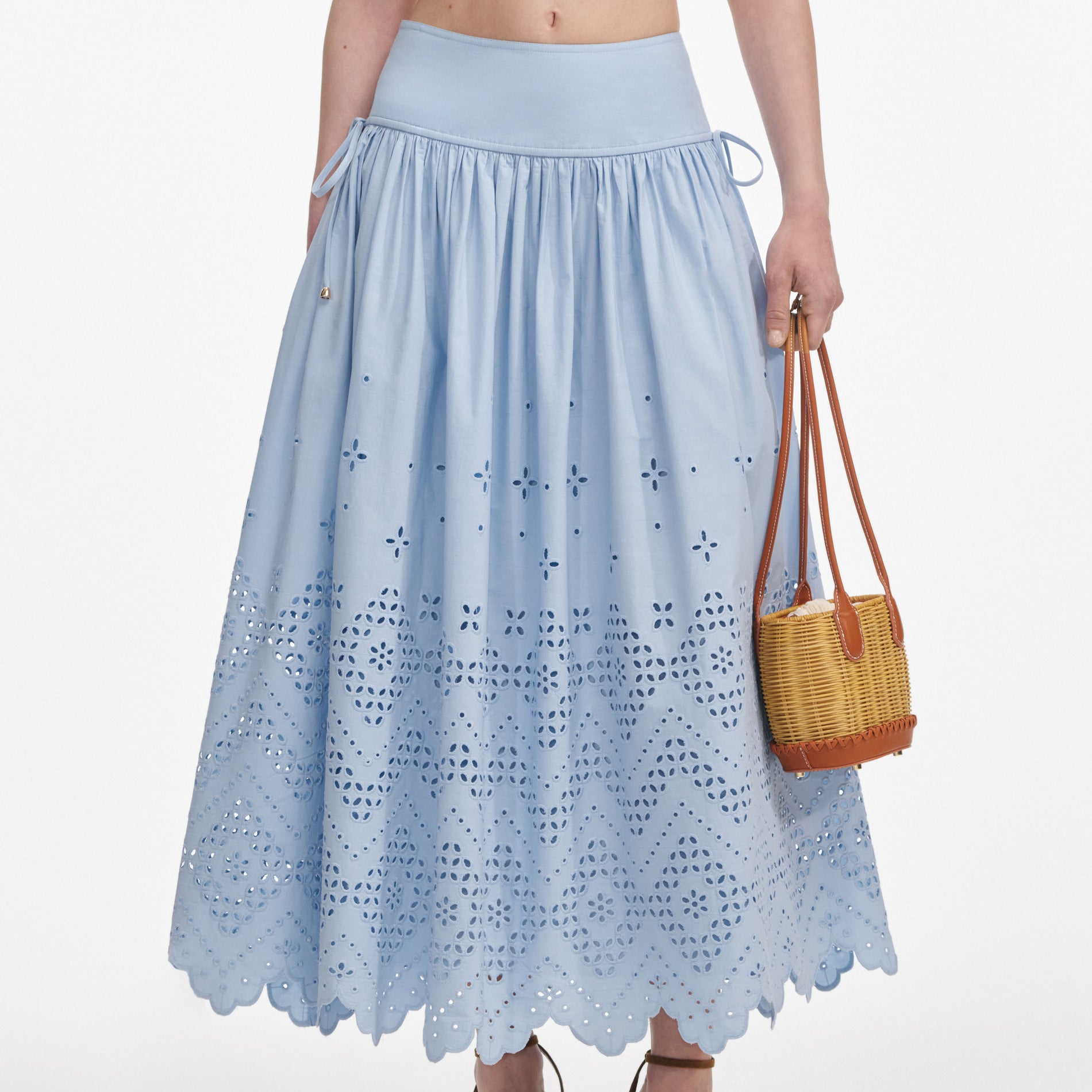 A close up of a woman wearing the Blue Cotton Broderie Midi Skirt