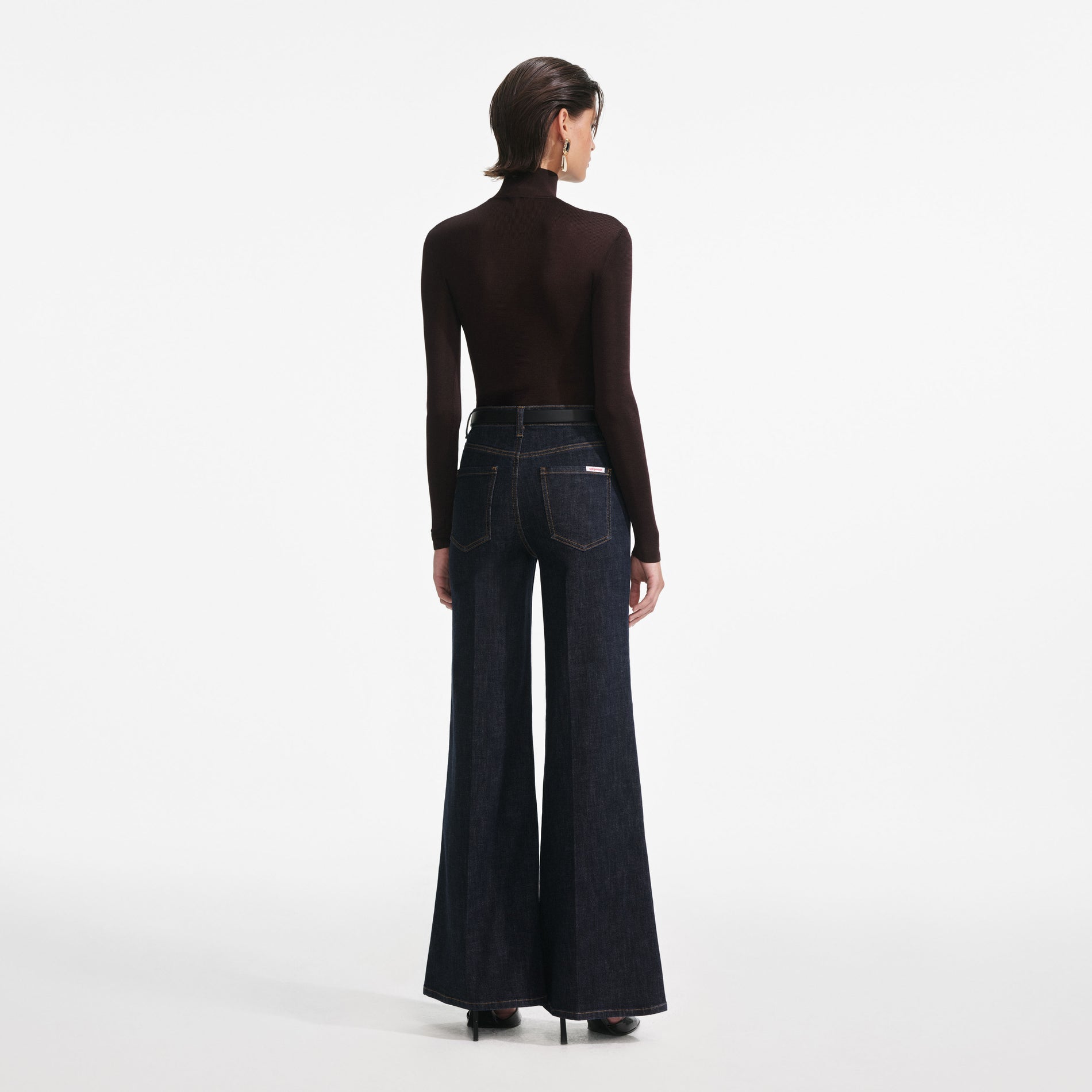 Back view of a woman wearing the Indigo Flared Jeans
