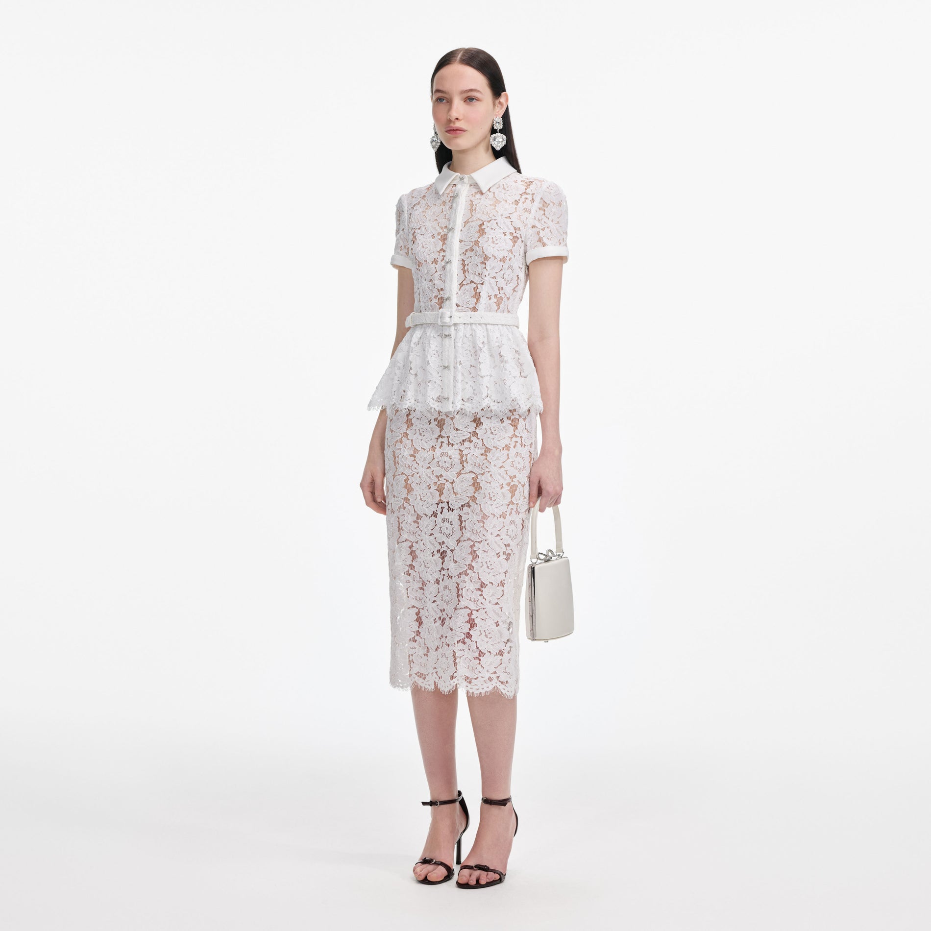 Side view of a woman wearing the White Lace Peplum Midi Dress