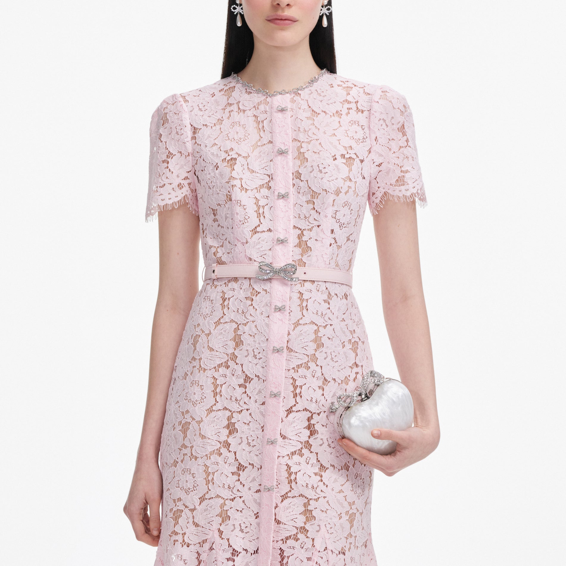 A close up of a woman wearing the Pink Lace Bow Trim Midi Dress