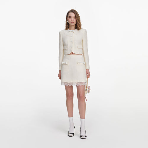 Front view of a woman wearing the Cream Boucle Lace Mini Skirt