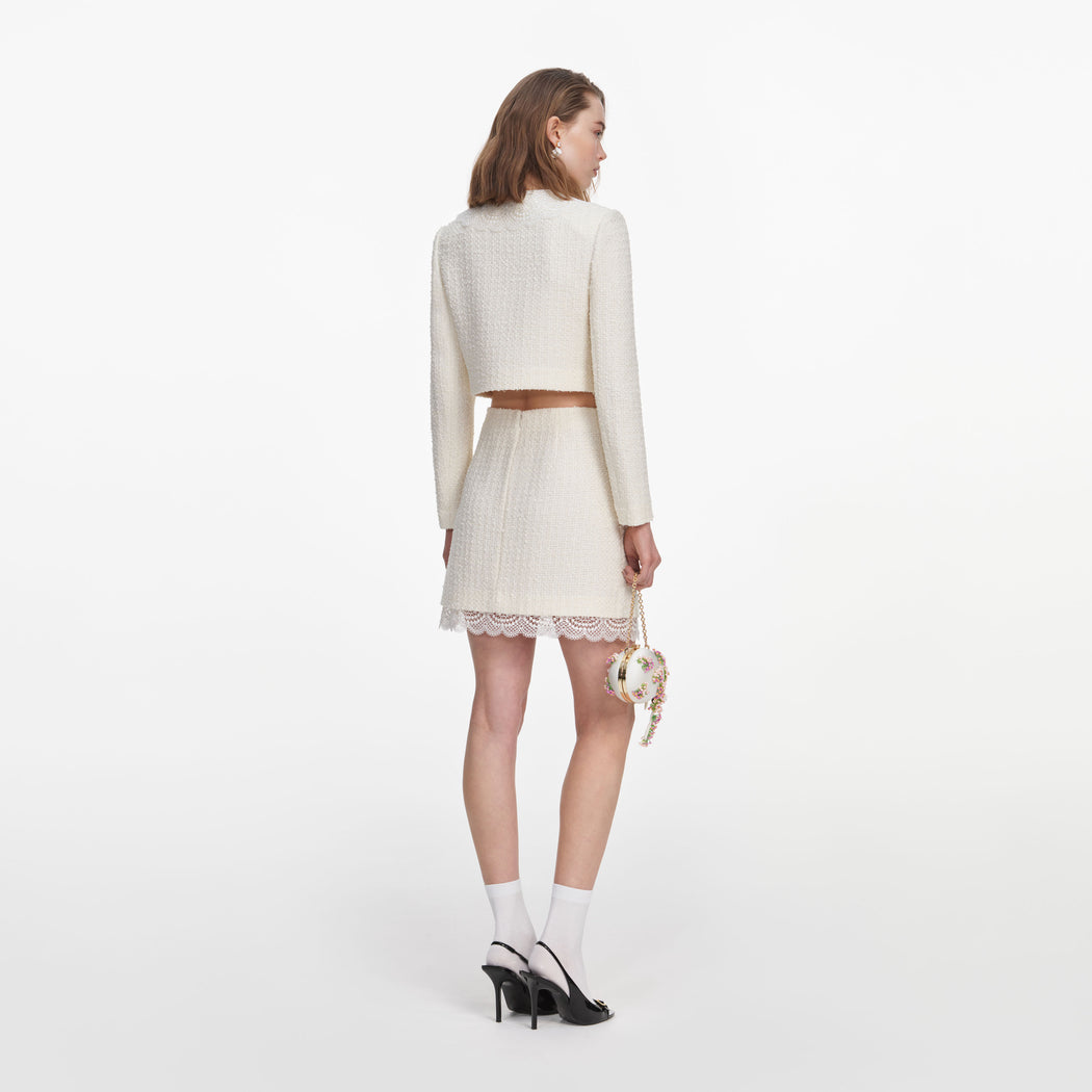 Back view of a woman wearing the Cream Boucle Lace Mini Skirt