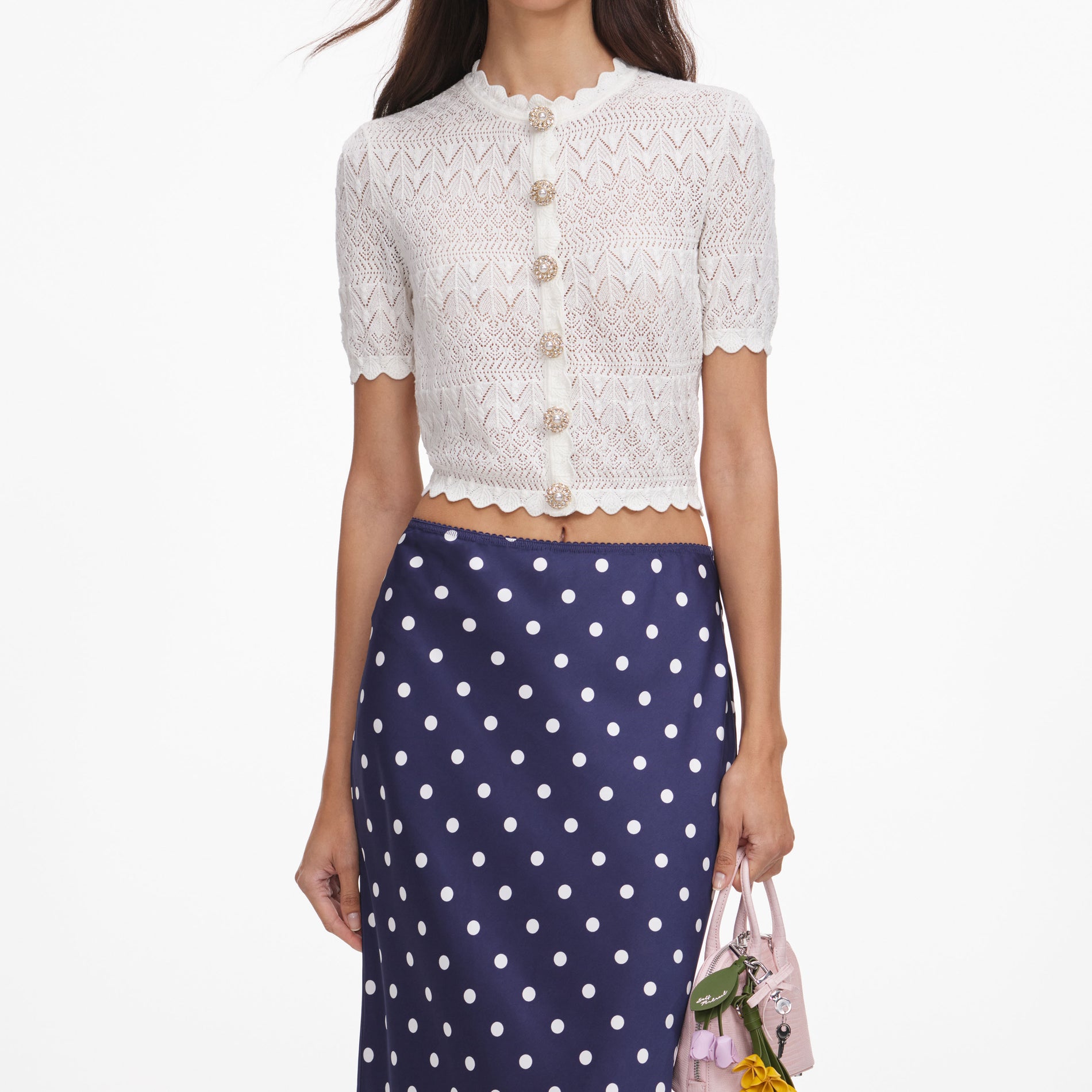 A close up of a woman wearing the White Pointelle Knit Top