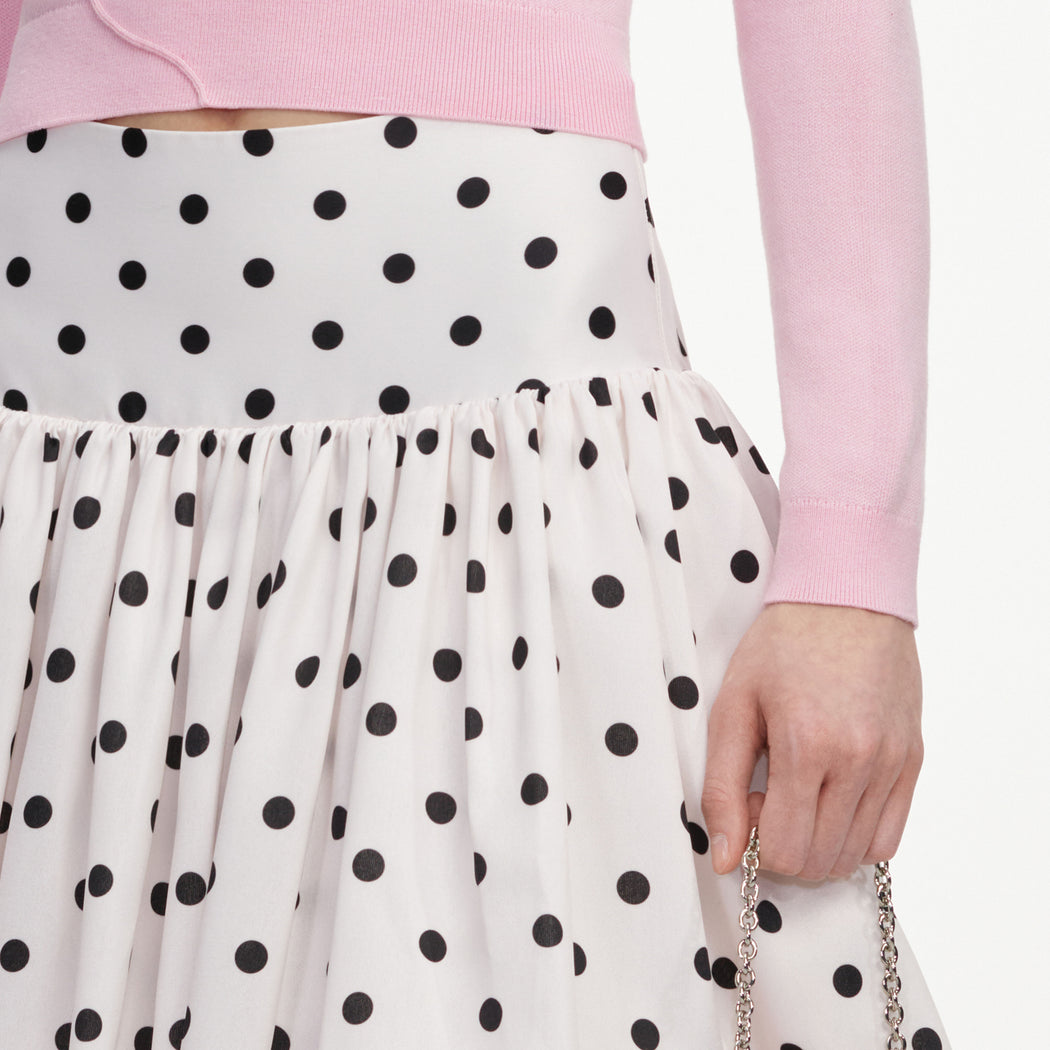 A close up of a woman wearing the Cream Polka Dot Taffeta Midi Skirt
