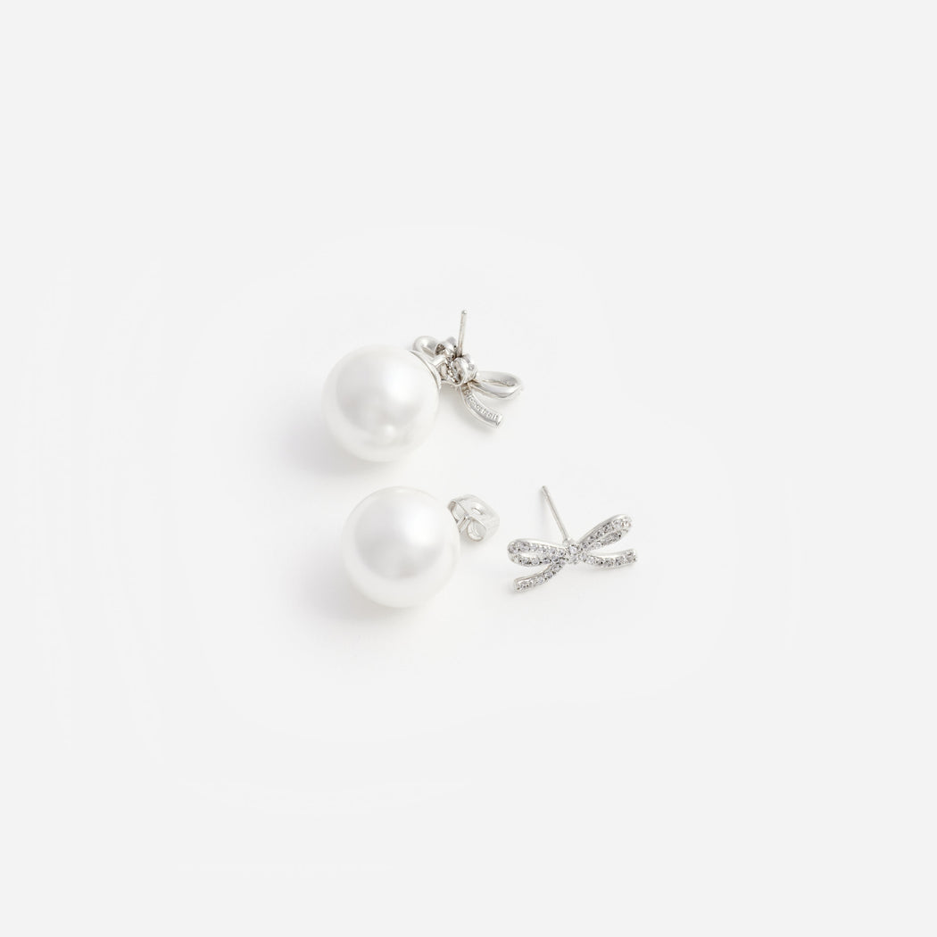 A close up of a woman wearing the Crystal Bow Pearl Back Earrings