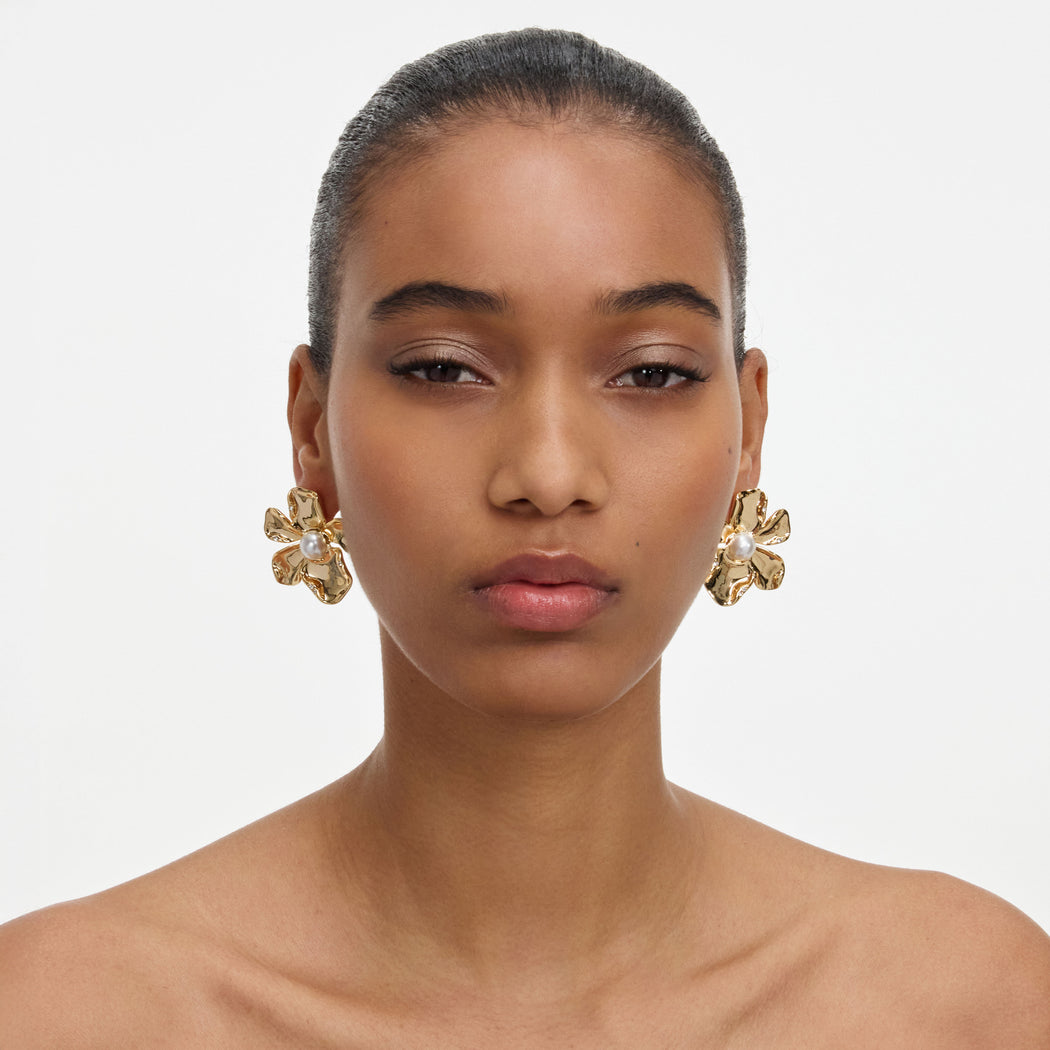 A close up of a woman wearing the Gold Pearl Flower Earrings