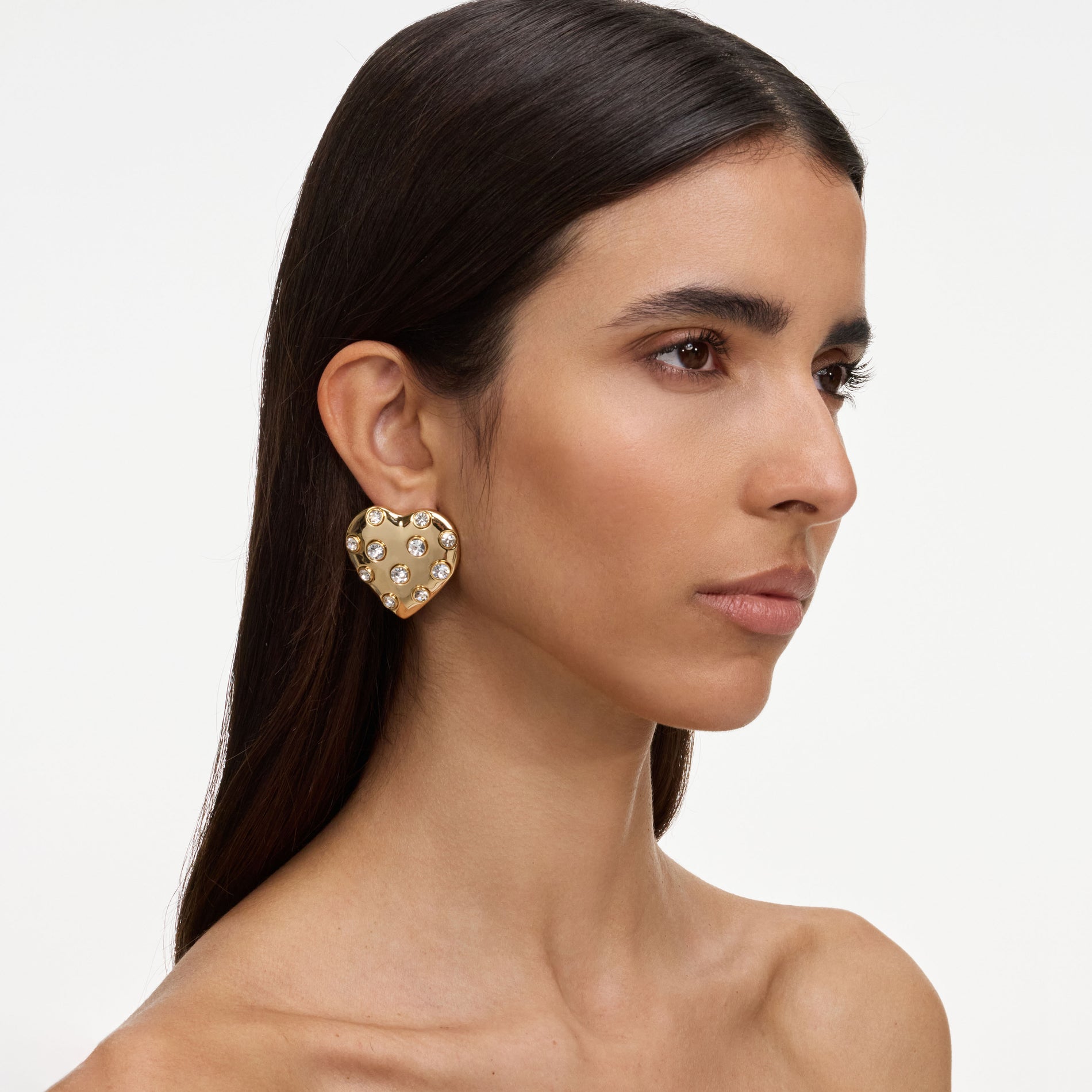 A close up of a woman wearing the Gold Crystal Heart Earrings