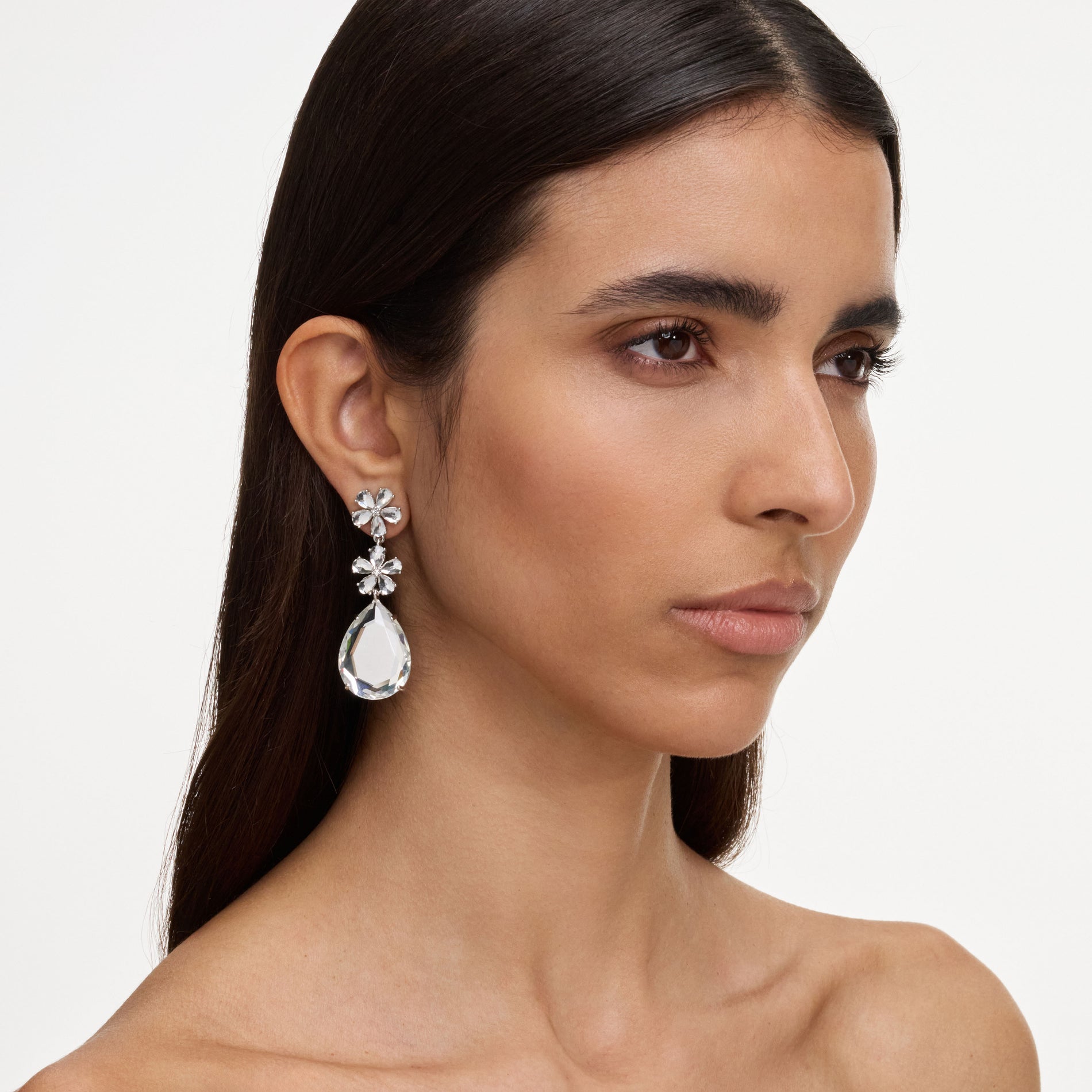 A close up of a woman wearing the Crystal Flower Tiered Earrings