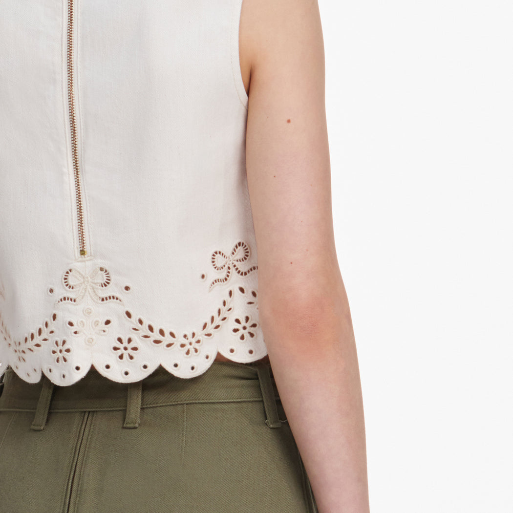 A close up of a woman wearing the Cream Broderie Denim Top