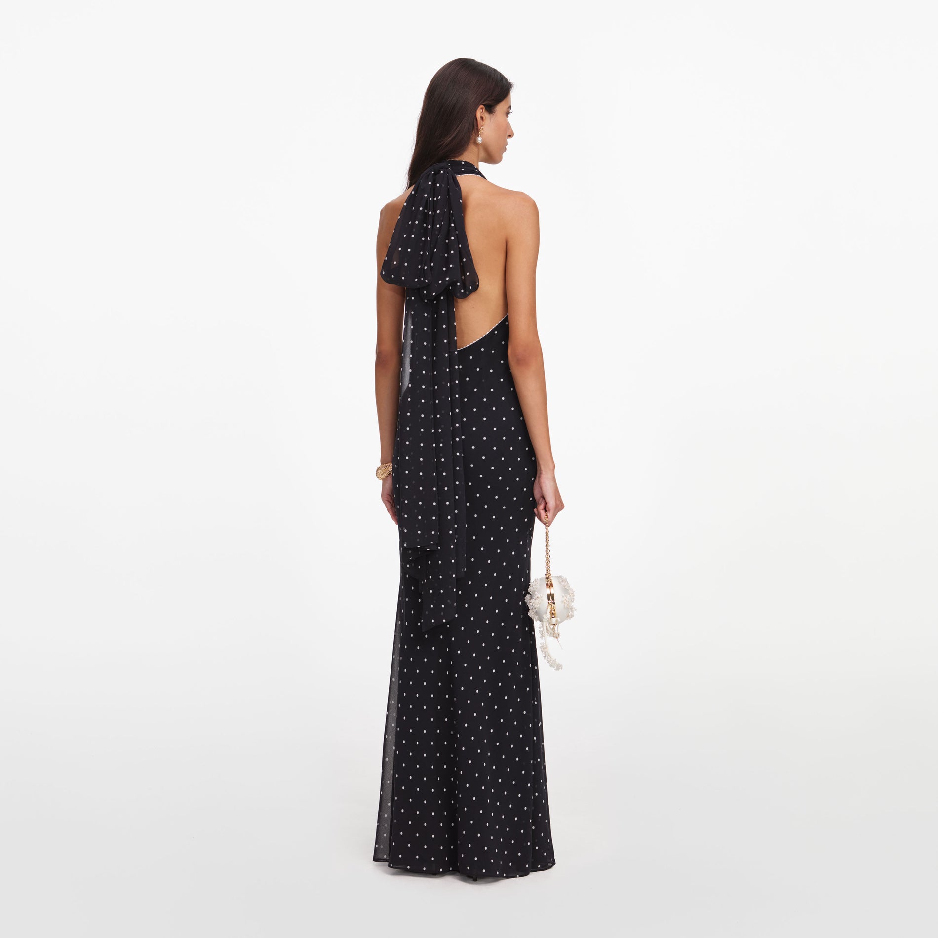 Back view of a woman wearing the Black Polka Dot Halter Neck Maxi Dress