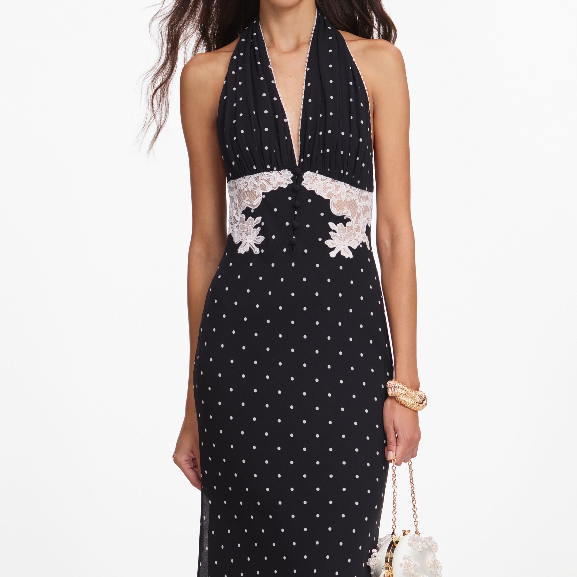 A close up of a woman wearing the Black Polka Dot Halter Neck Maxi Dress