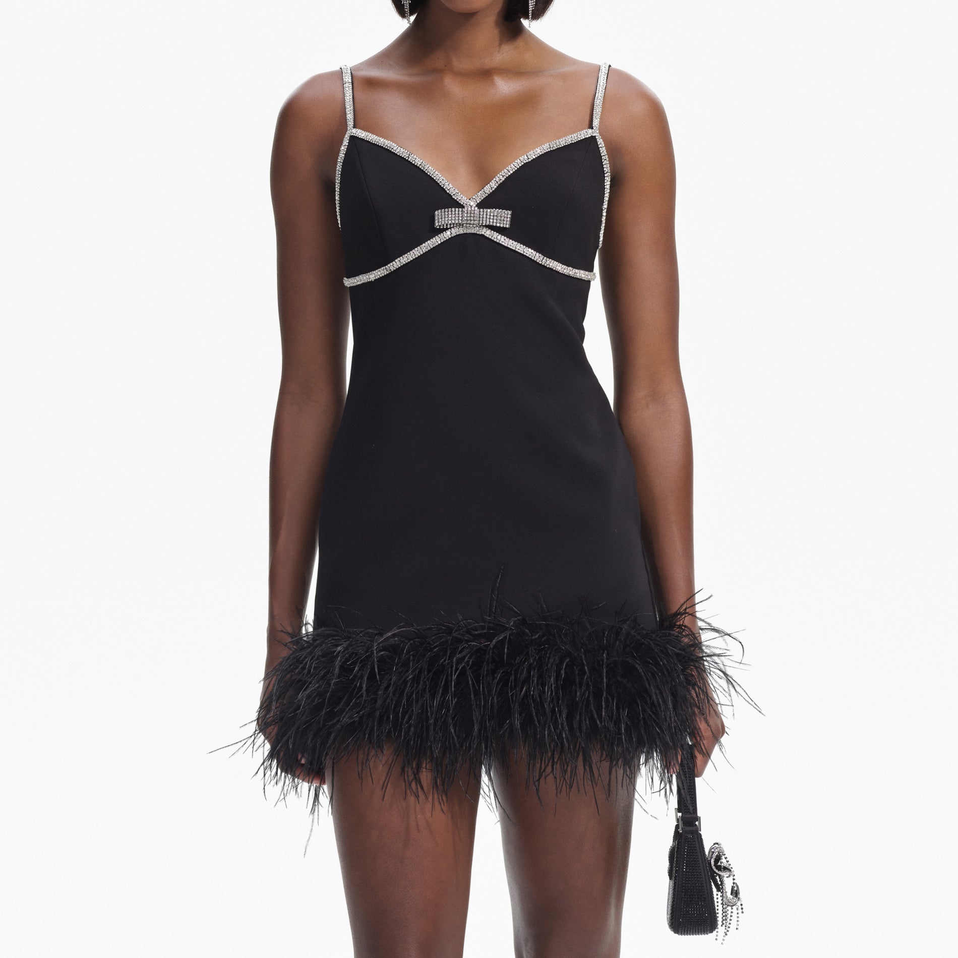 A close up of a woman wearing the Black Crepe Feather Swing Mini Dress