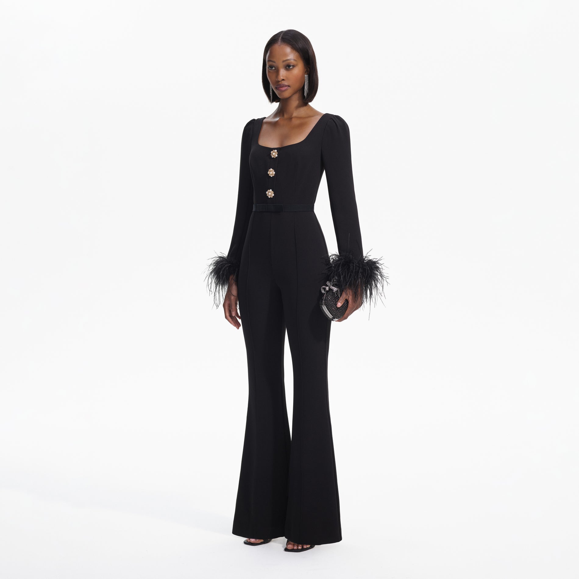 Side view of a woman wearing the Black Crepe Feather Jumpsuit