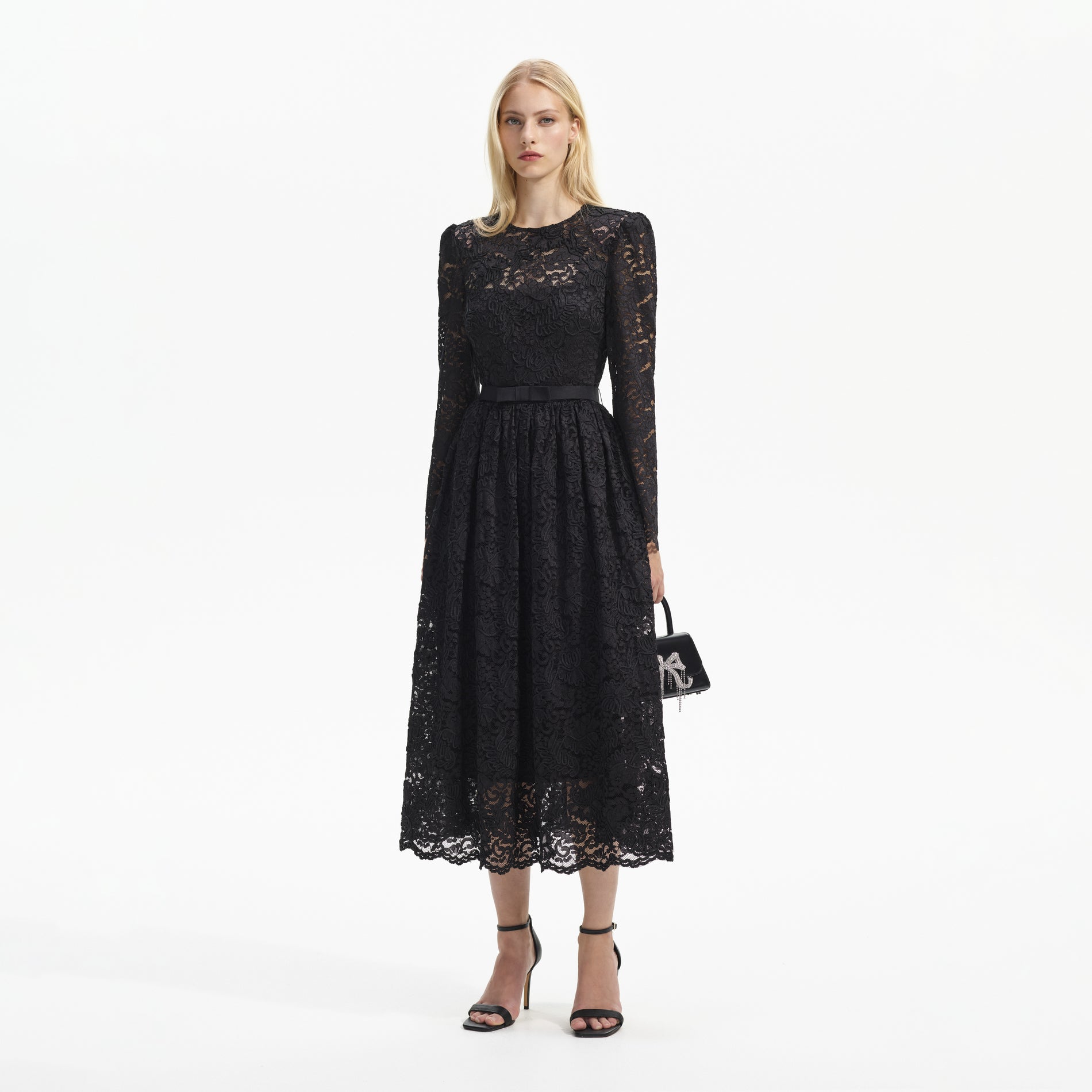 Side view of a woman wearing the Black Cord Lace Long Sleeve Midi Dress