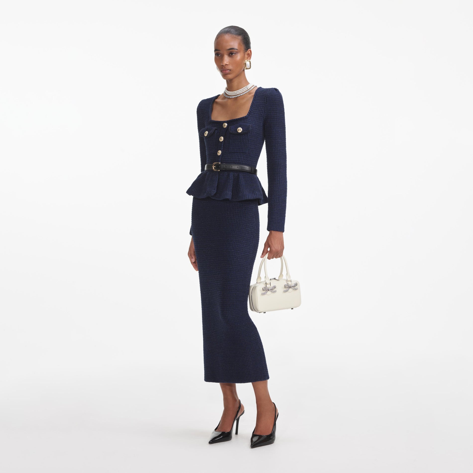 Side view of a woman wearing the Navy Knit Peplum Midi Dress