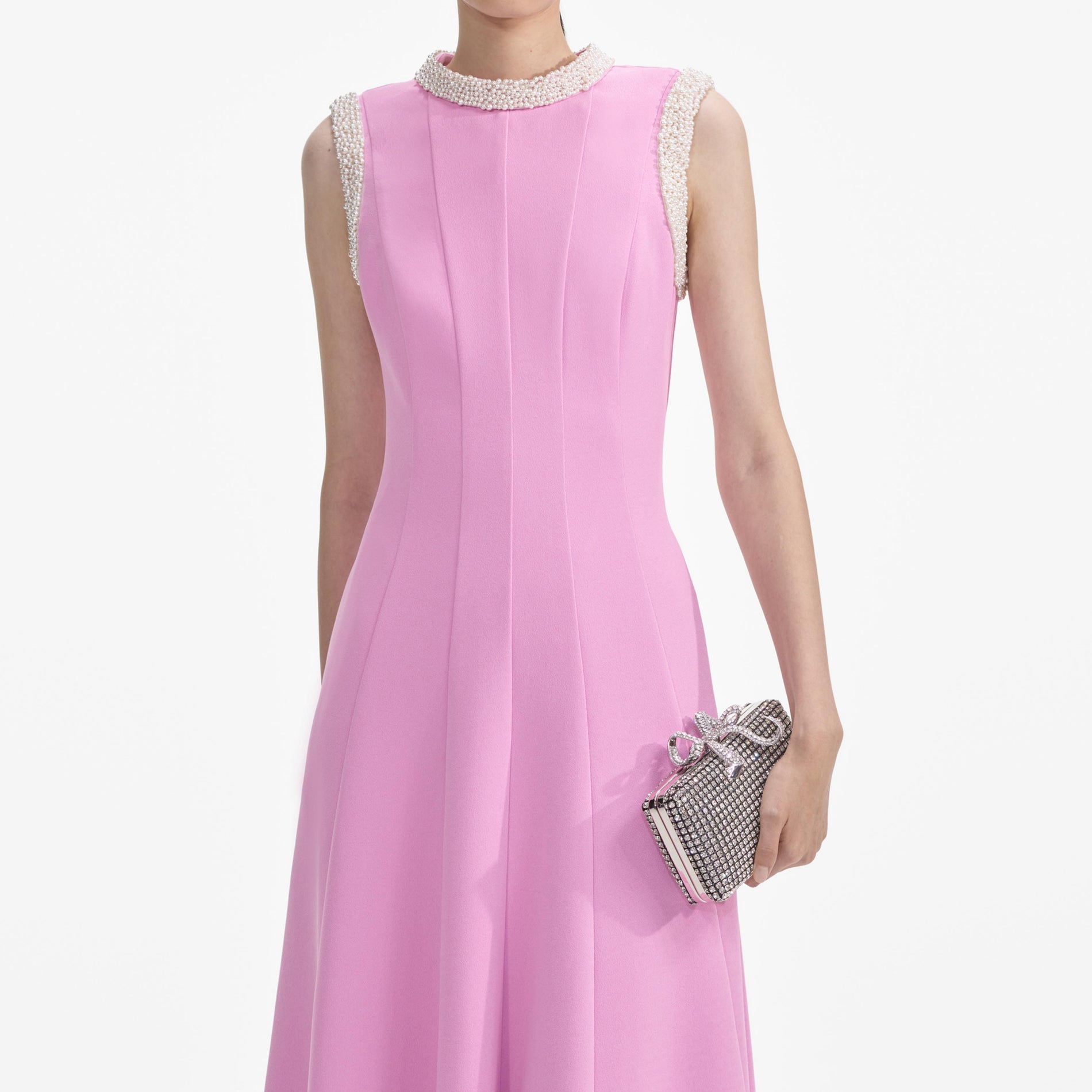 A close up of a woman wearing the Pink Crepe Pearl Trim Midi Dress