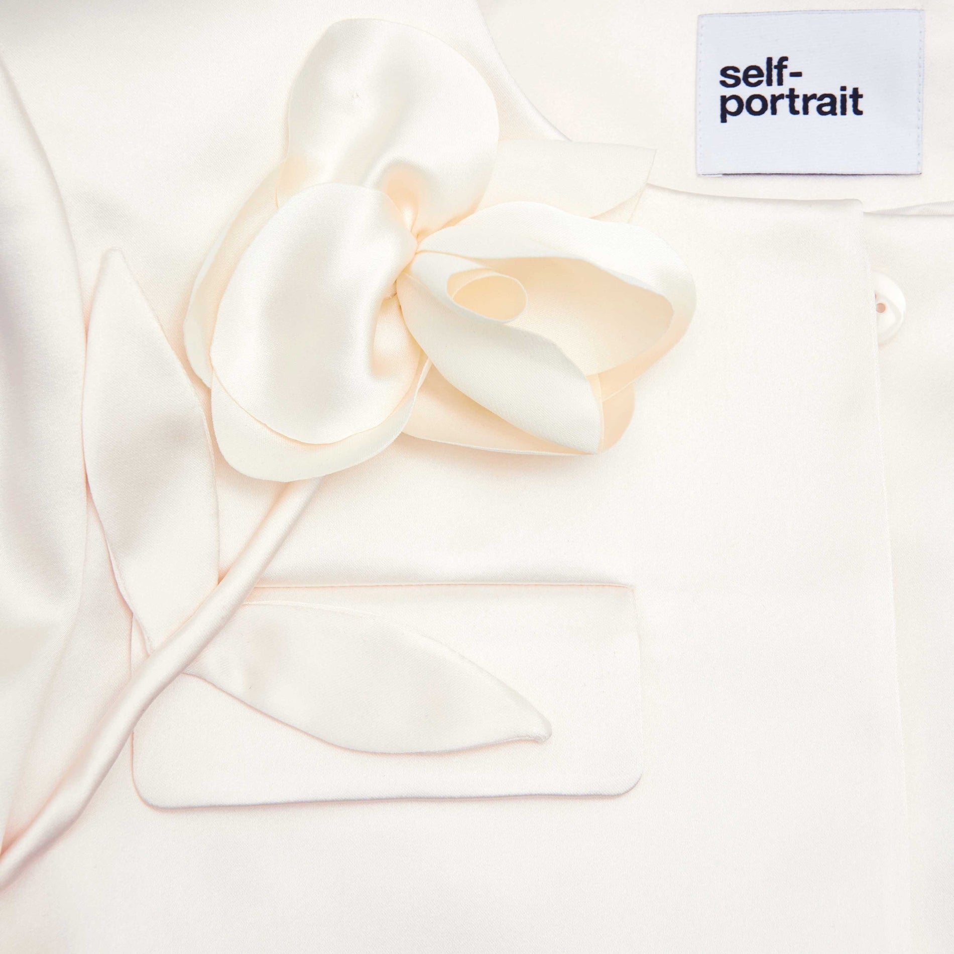 A close up of the fabric for the Cream 3D Flower Satin Jacket