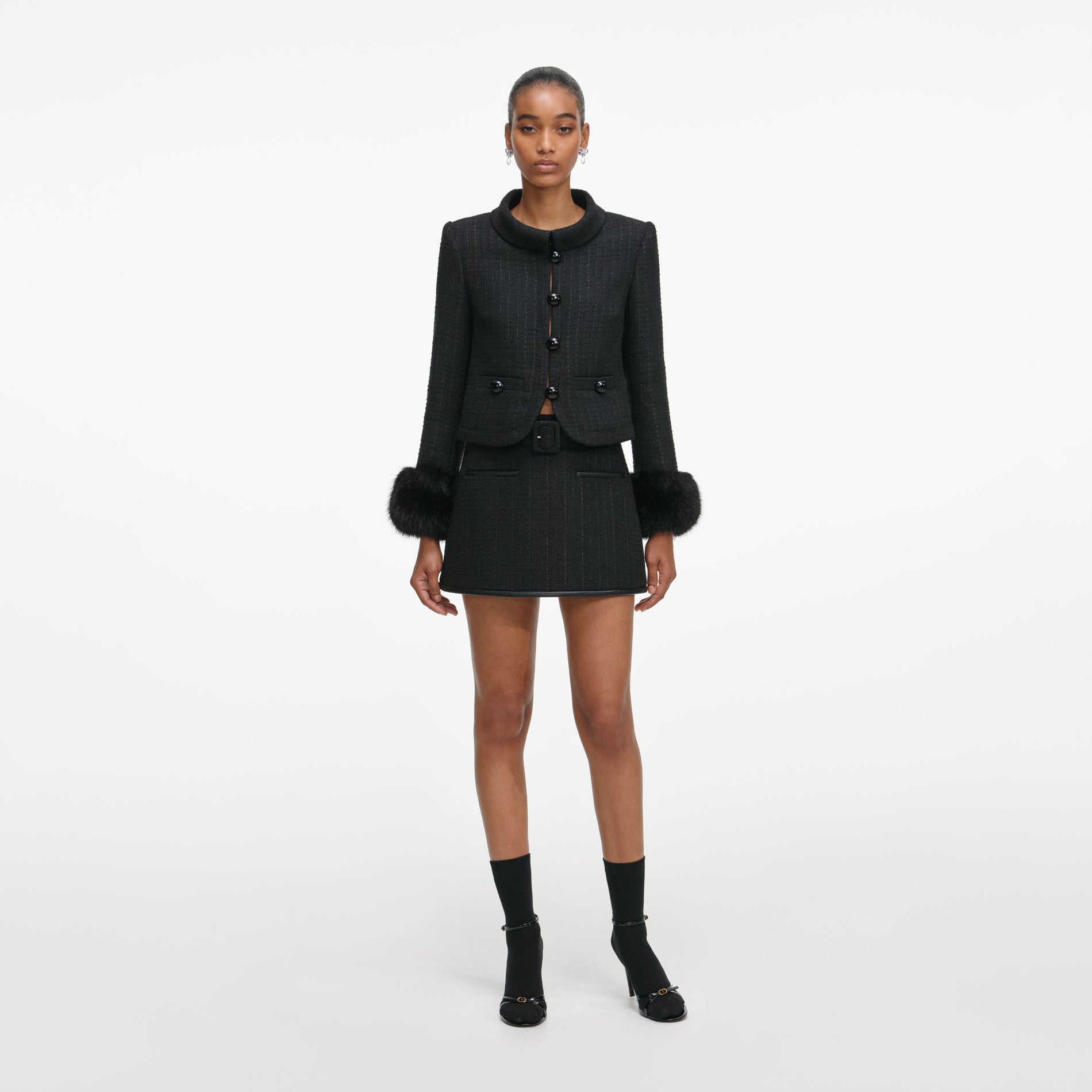 Front view of a woman wearing the Black Boucle Faux Fur Cuff Jacket