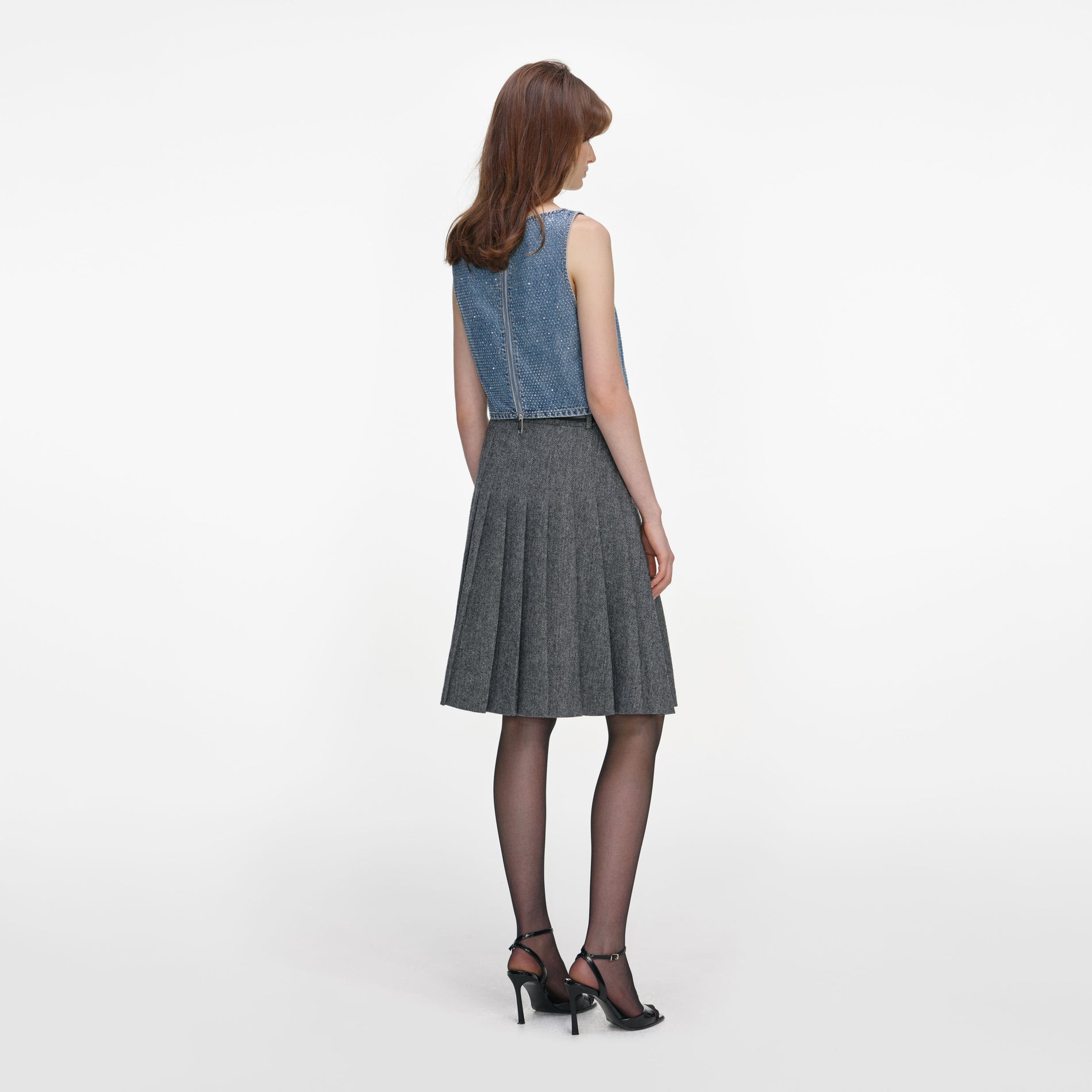 Back view of a woman wearing the Grey Herringbone Pleated Midi Skirt