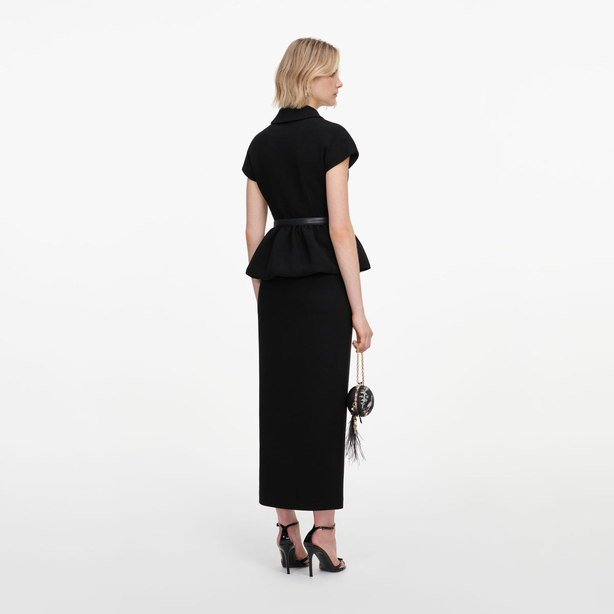 Back view of a woman wearing the Black Crepe Peplum Midi Dress