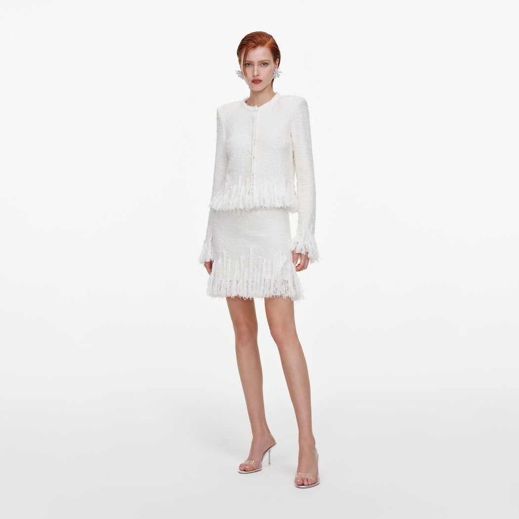 Side view of a woman wearing the White Fringe Knit Mini Skirt