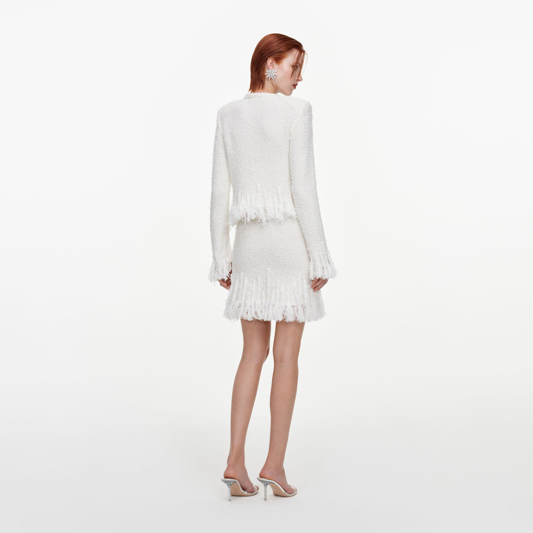 Back view of a woman wearing the White Fringe Knit Mini Skirt