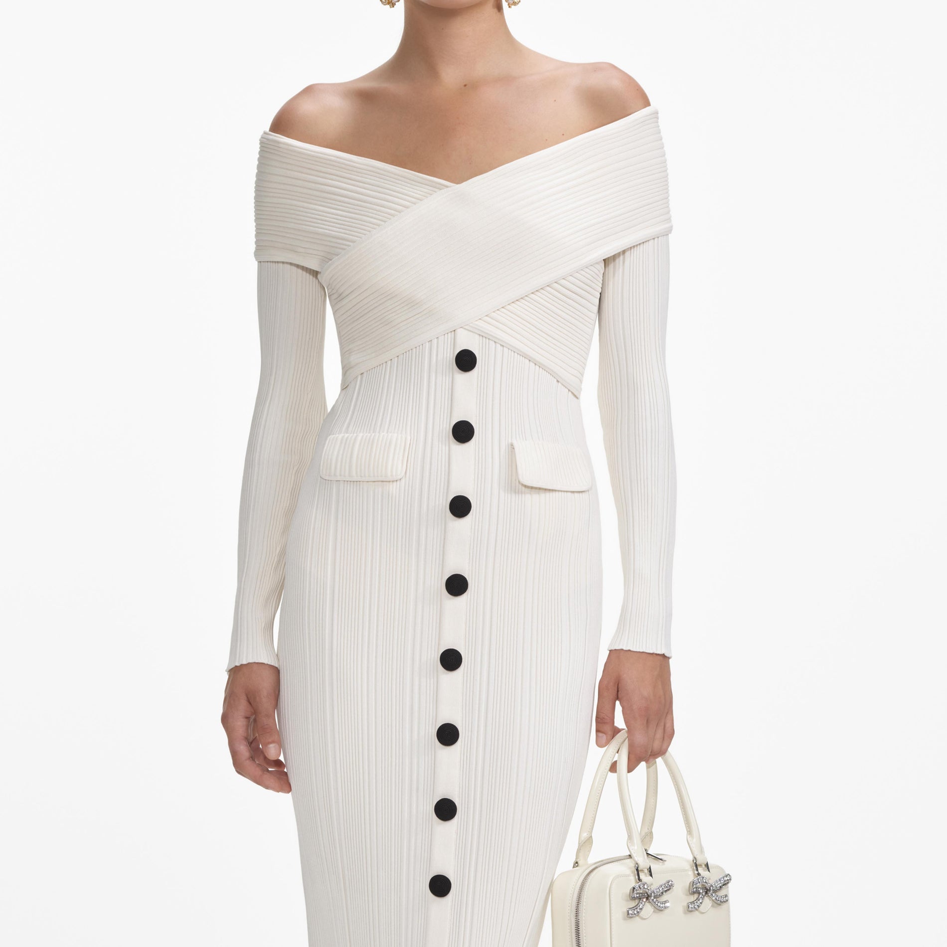 A close up of a woman wearing the Cream Off Shoulder Knit Midi Dress