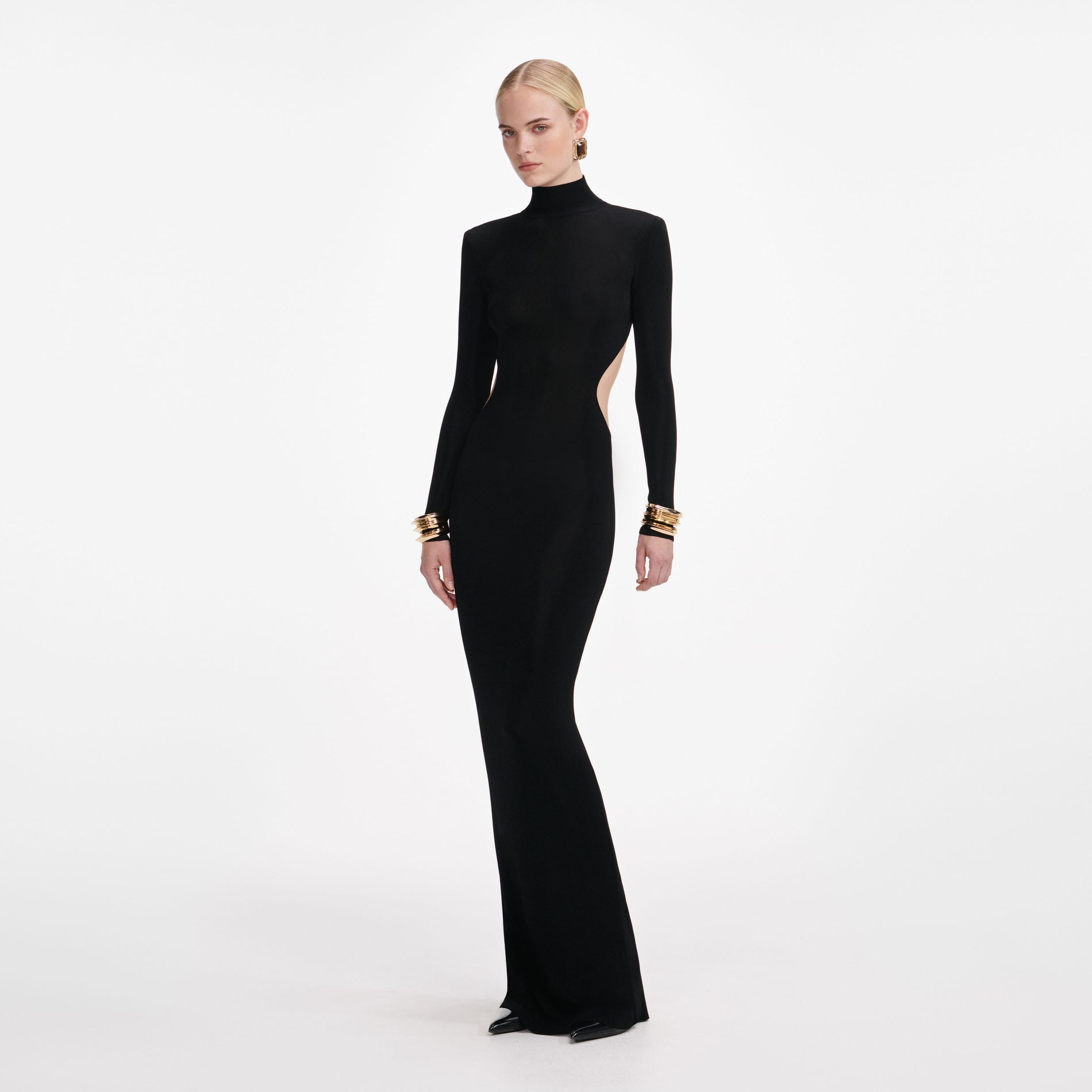 Side view of a woman wearing the Black Viscose Knit Cut Out Maxi Dress