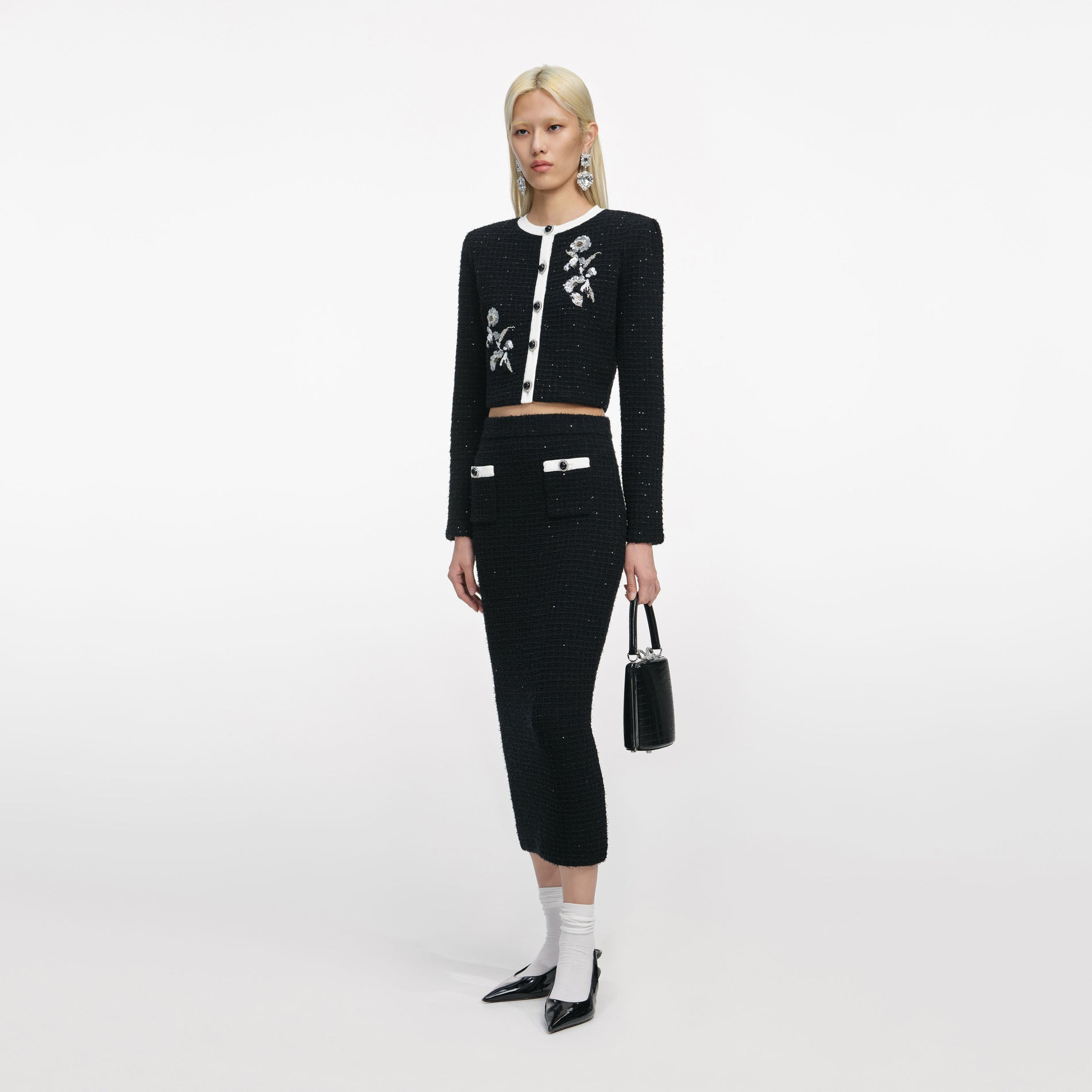 Side view of a woman wearing the Black Floral Textured Knit Jacket