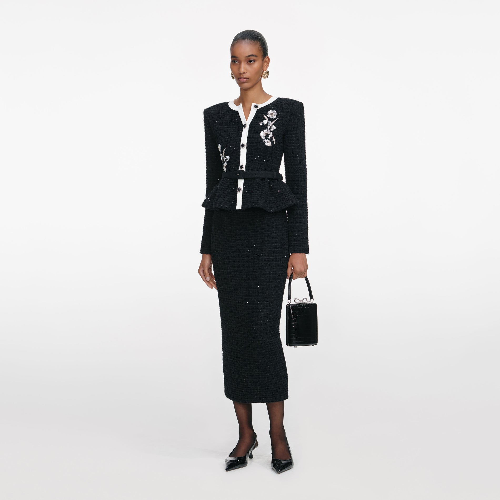 Side view of a woman wearing the Black Floral Textured Knit Midi Dress