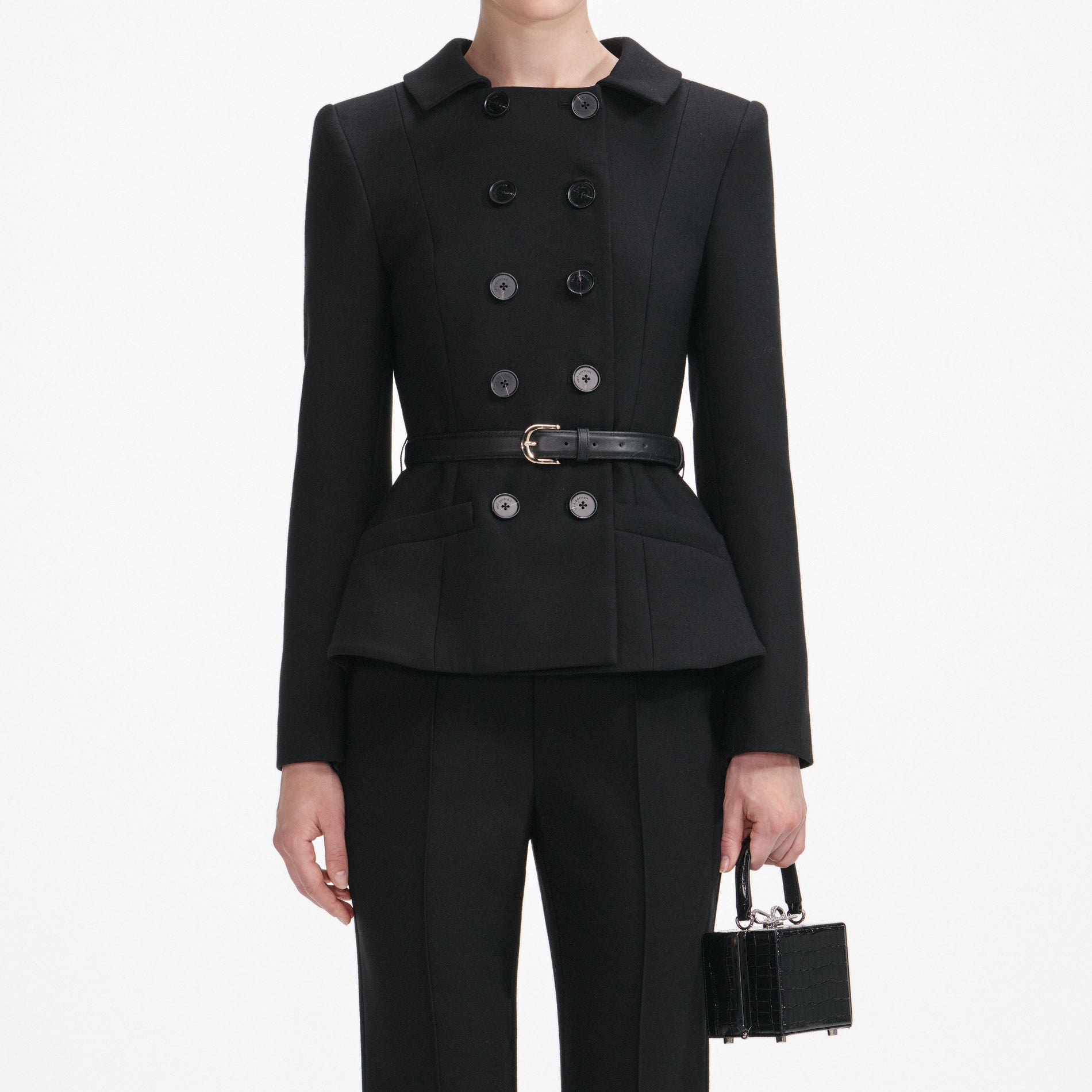 A close up of a woman wearing the Black Wool Double Breasted Jumpsuit