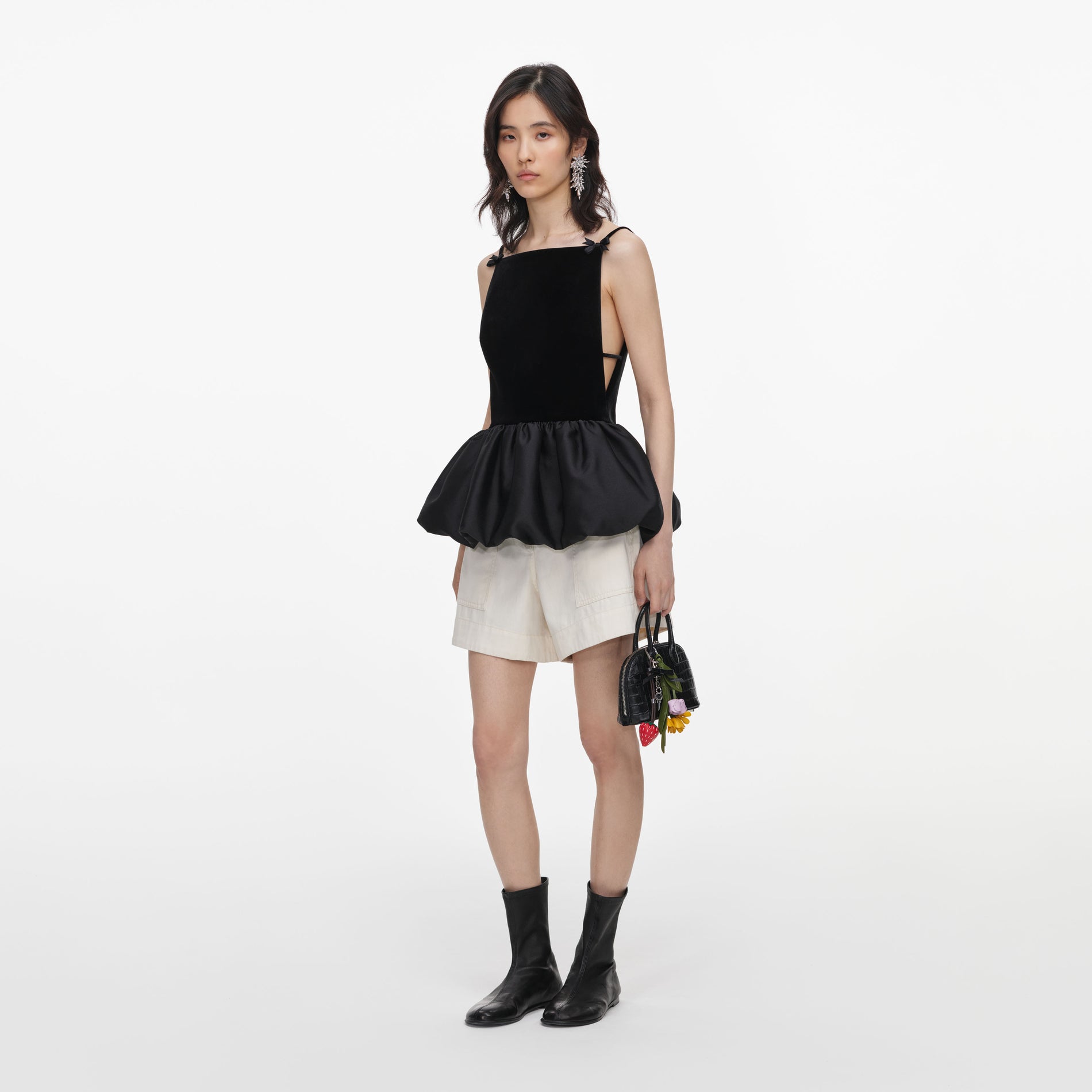 Side view of a woman wearing the Black Velvet Bubble Hem Top