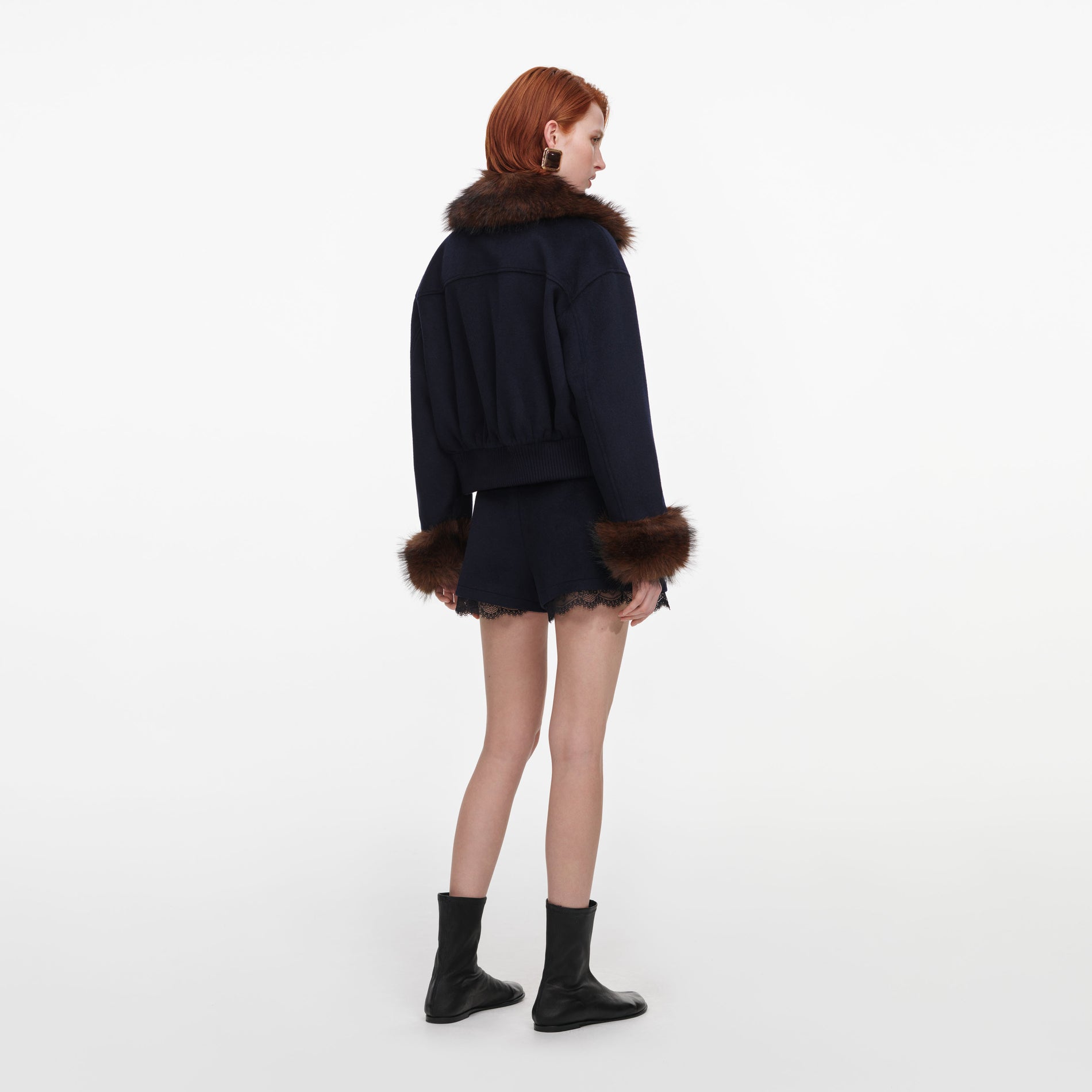 Back view of a woman wearing the Navy Wool Fur Trim Jacket
