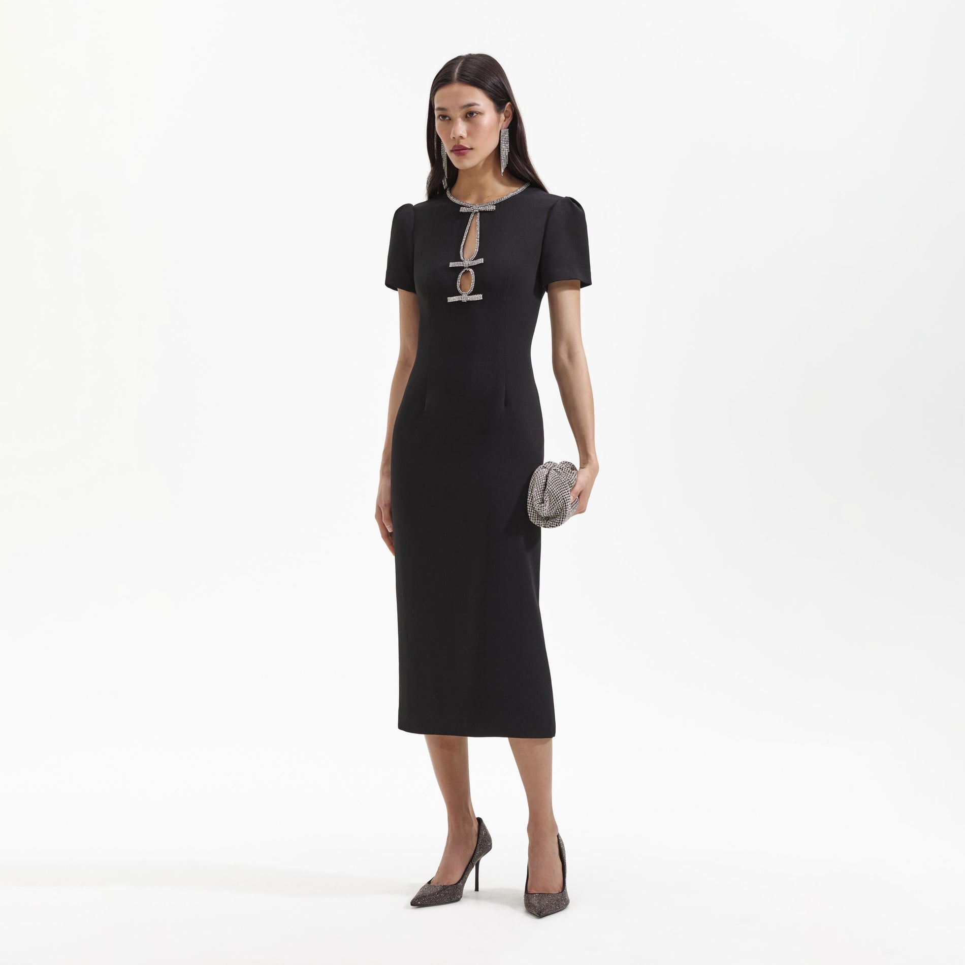Side view of a woman wearing the Black Crepe Diamante Bow Midi Dress