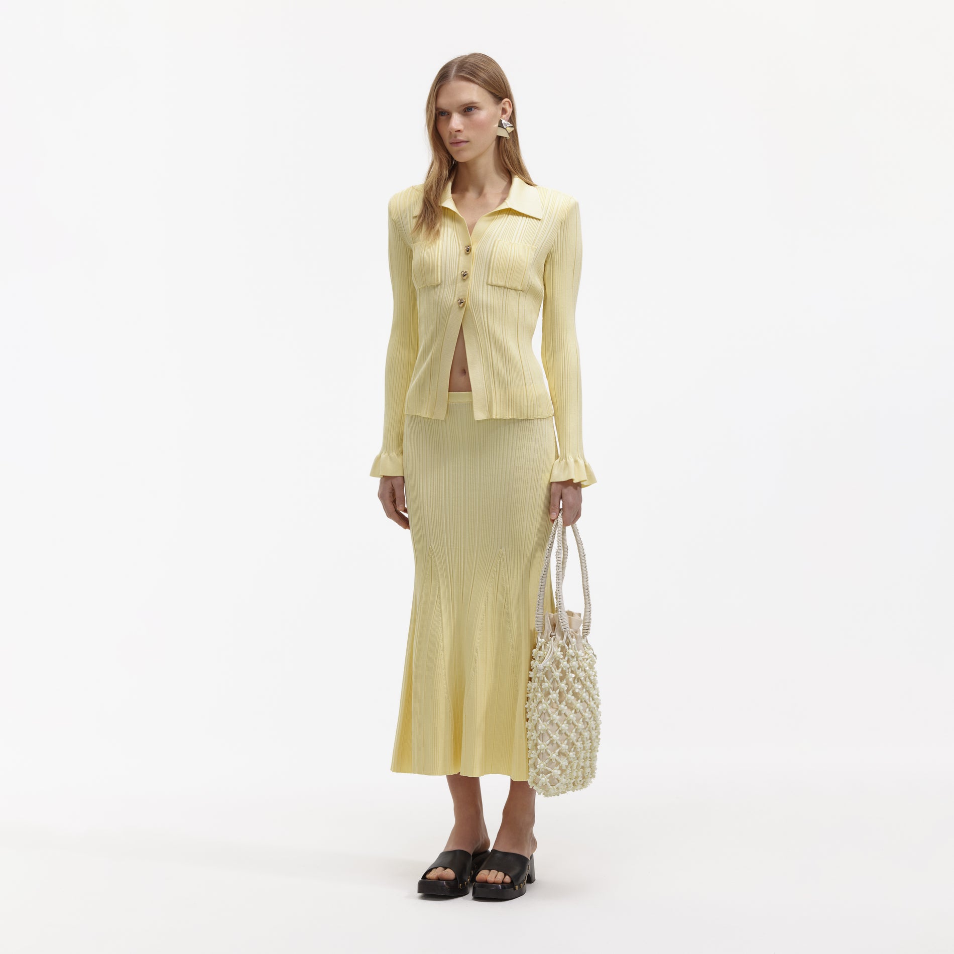 Side view of a woman wearing the Yellow Ribbed Viscose Knit Skirt