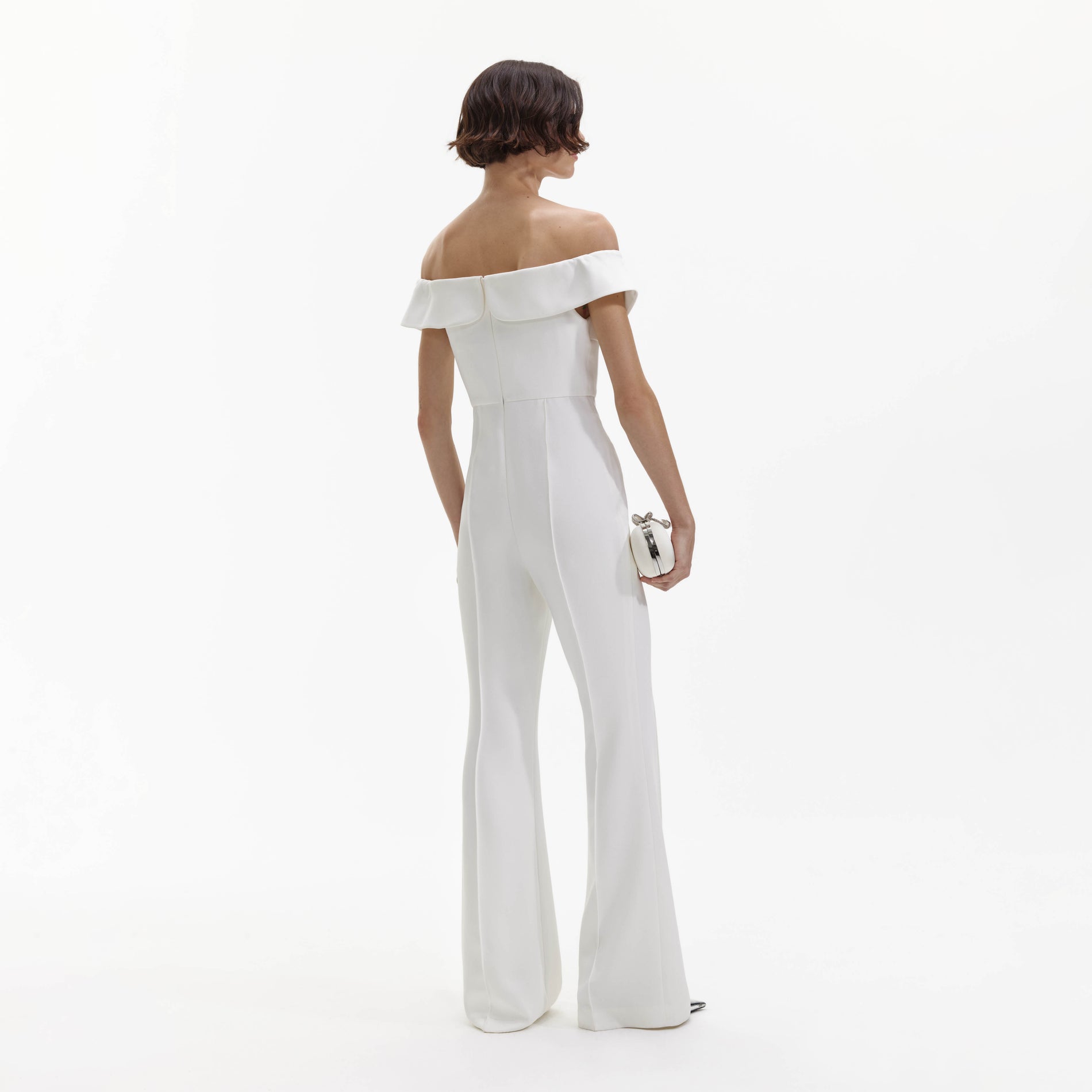 Back view of a woman wearing the White Crepe Bow Jumpsuit