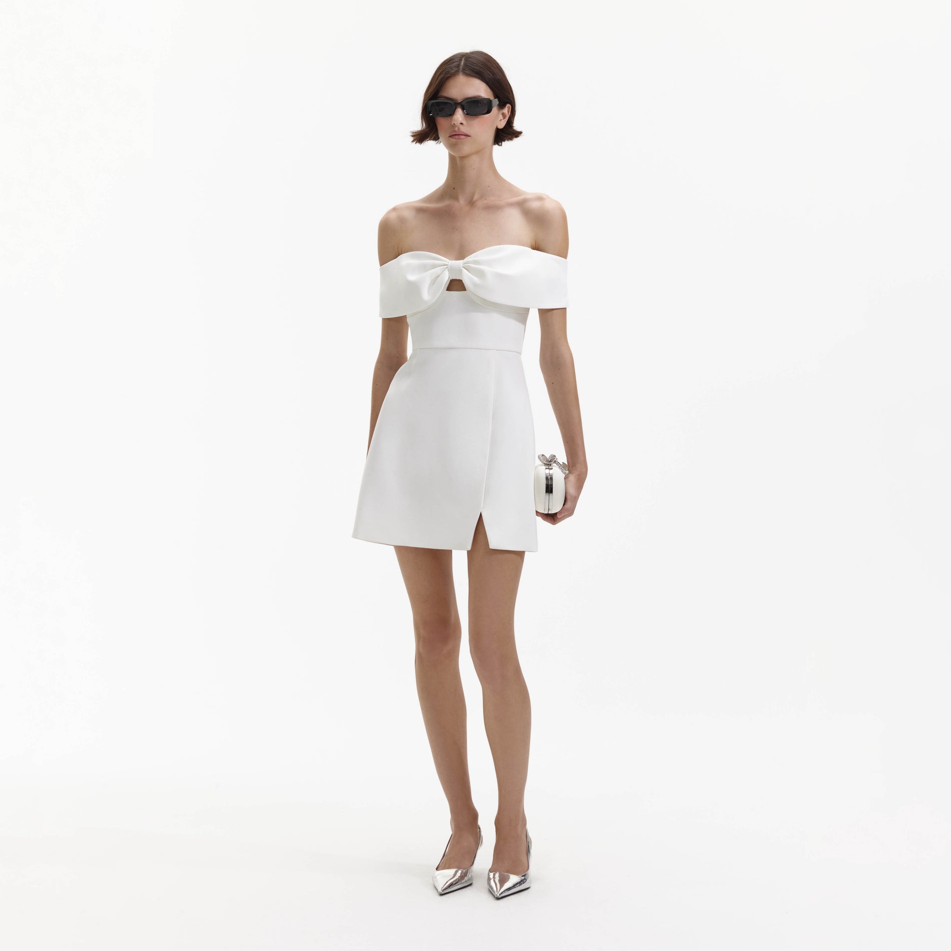 Side view of a woman wearing the White Bow Crepe Mini Dress