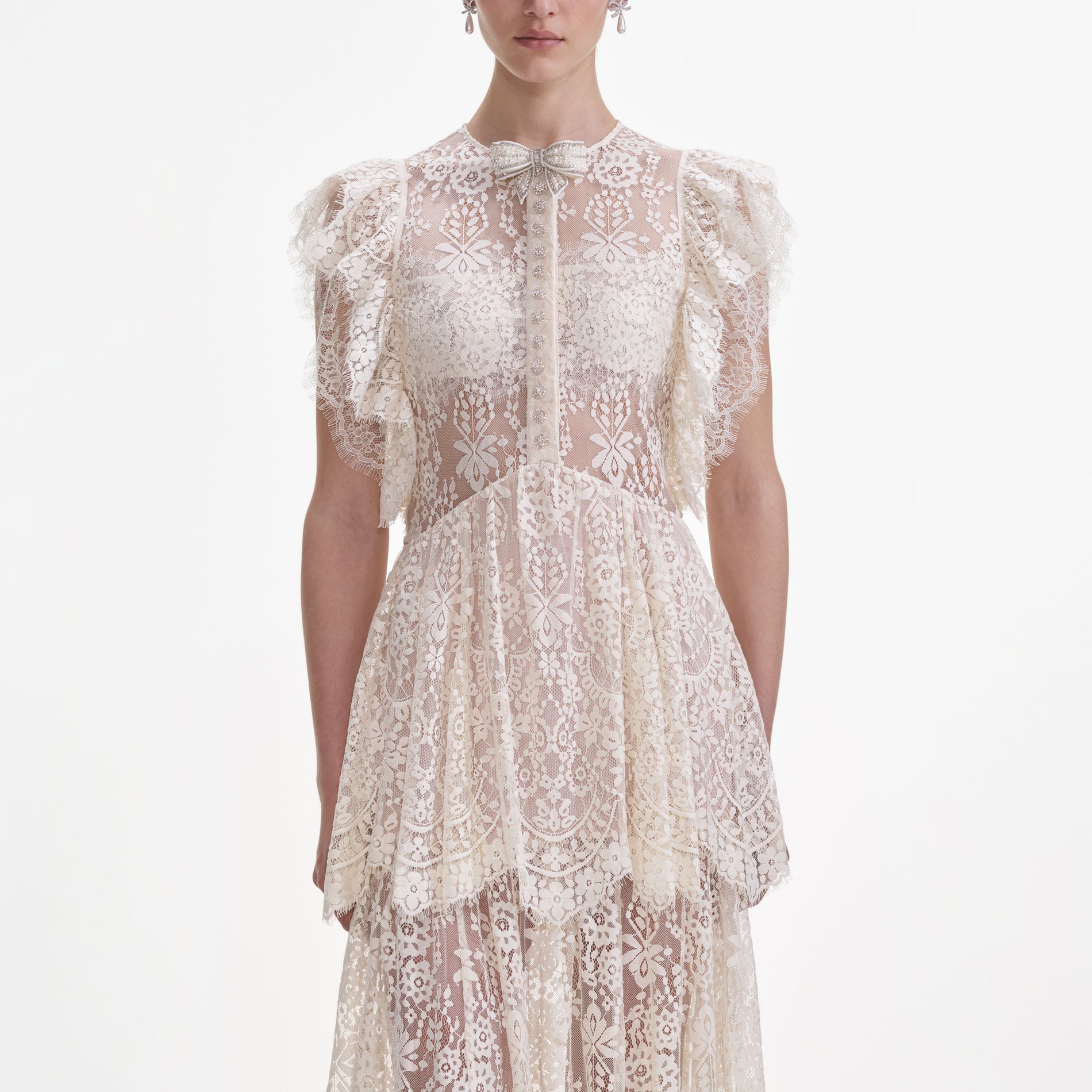 A close up of a woman wearing the White Tiered Lace Maxi Dress