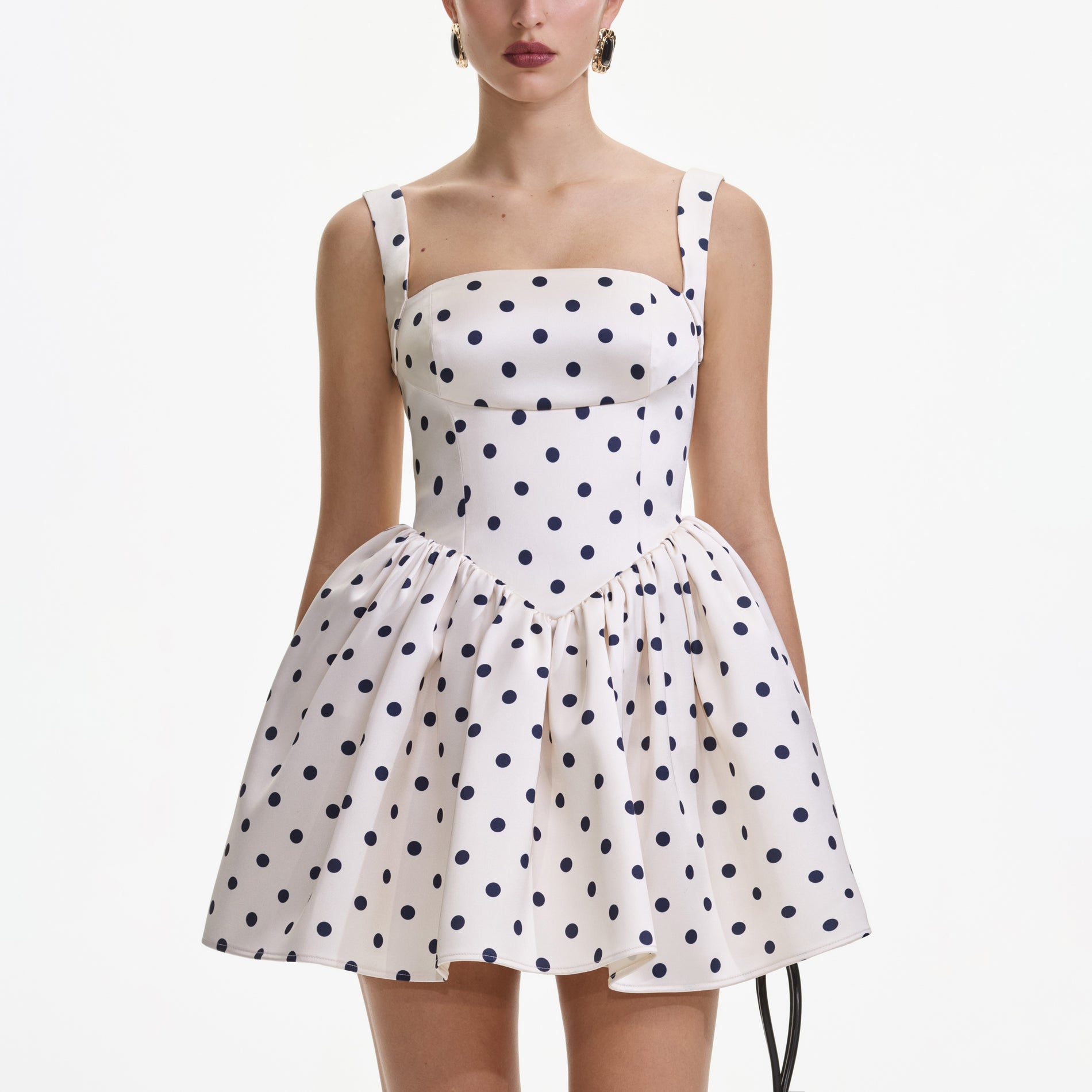 A close up of a woman wearing the Cream Polka Dot Satin Mini Dress