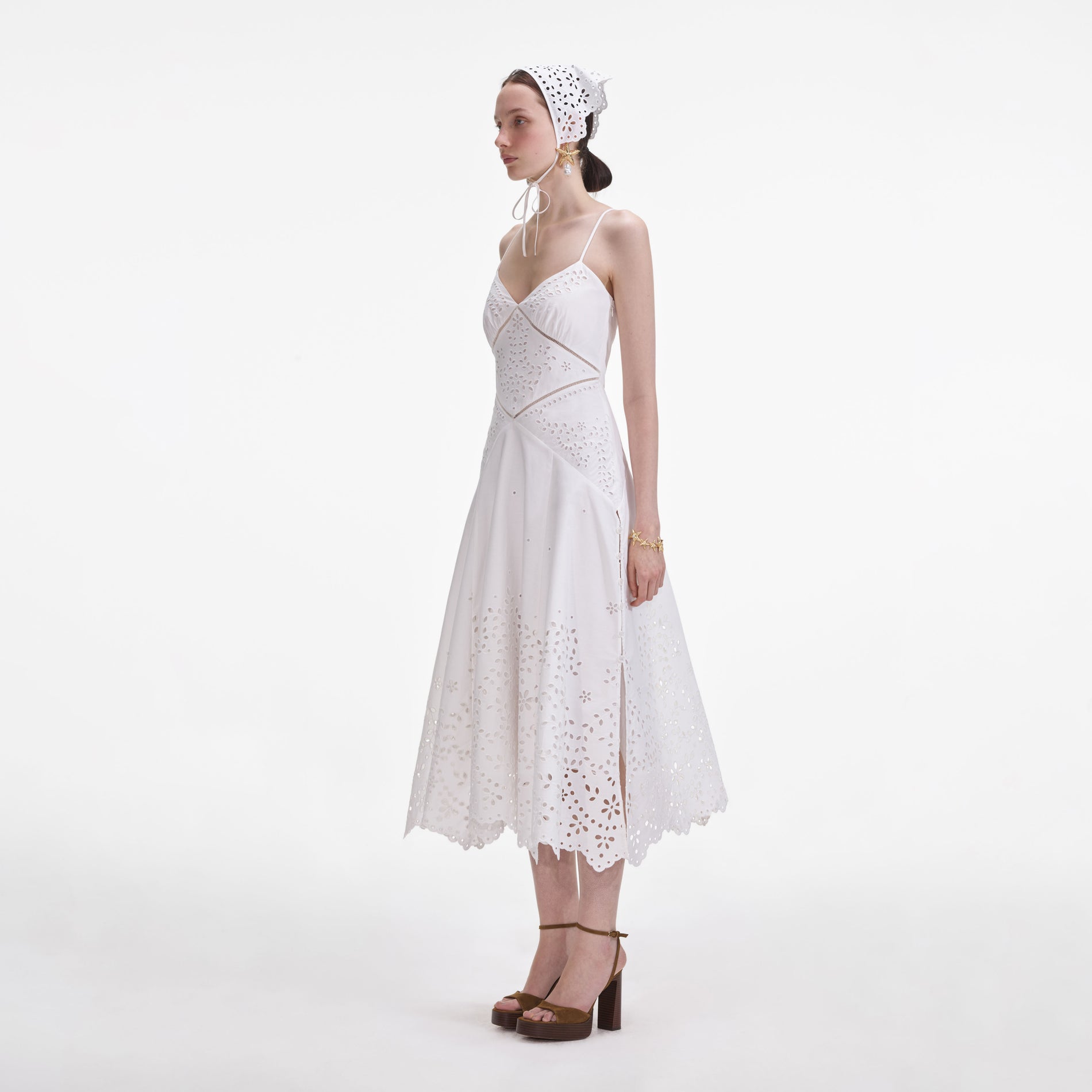 Side view of a woman wearing the White Cotton Embroidered Midi Dress