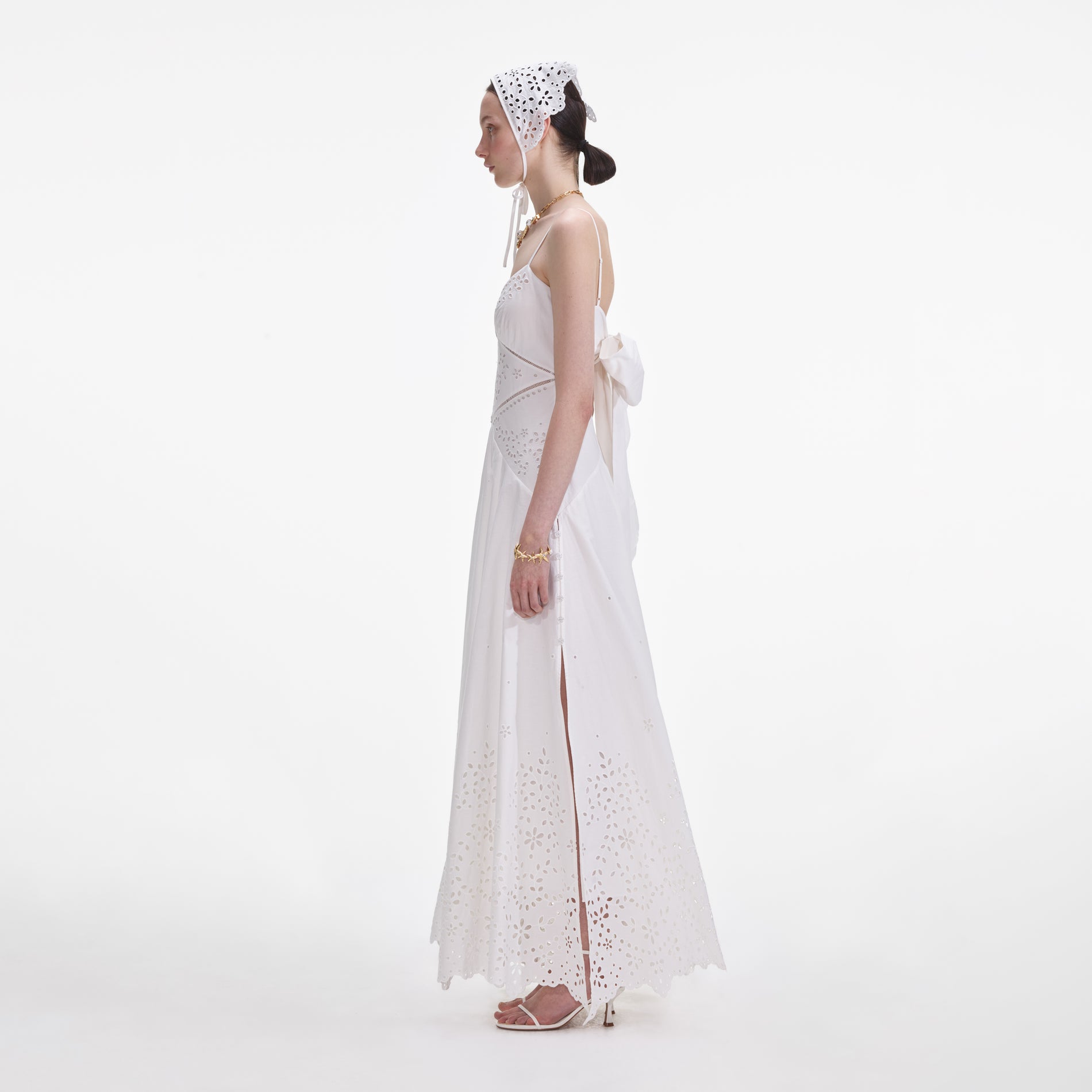 Side view of a woman wearing the White Cotton Embroidered Maxi Dress