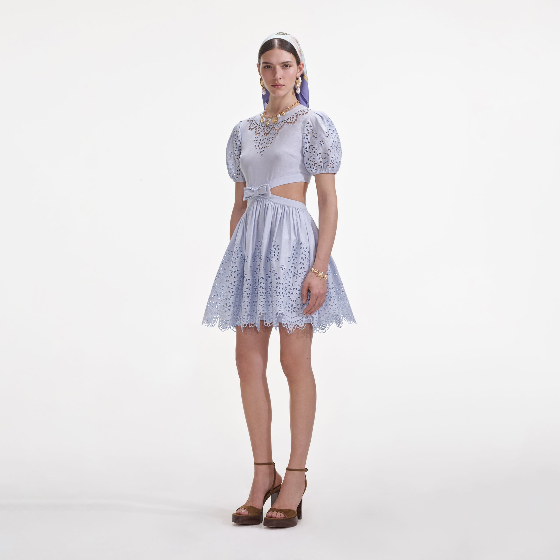 Side view of a woman wearing the Blue Embroidered Linen Mini Dress