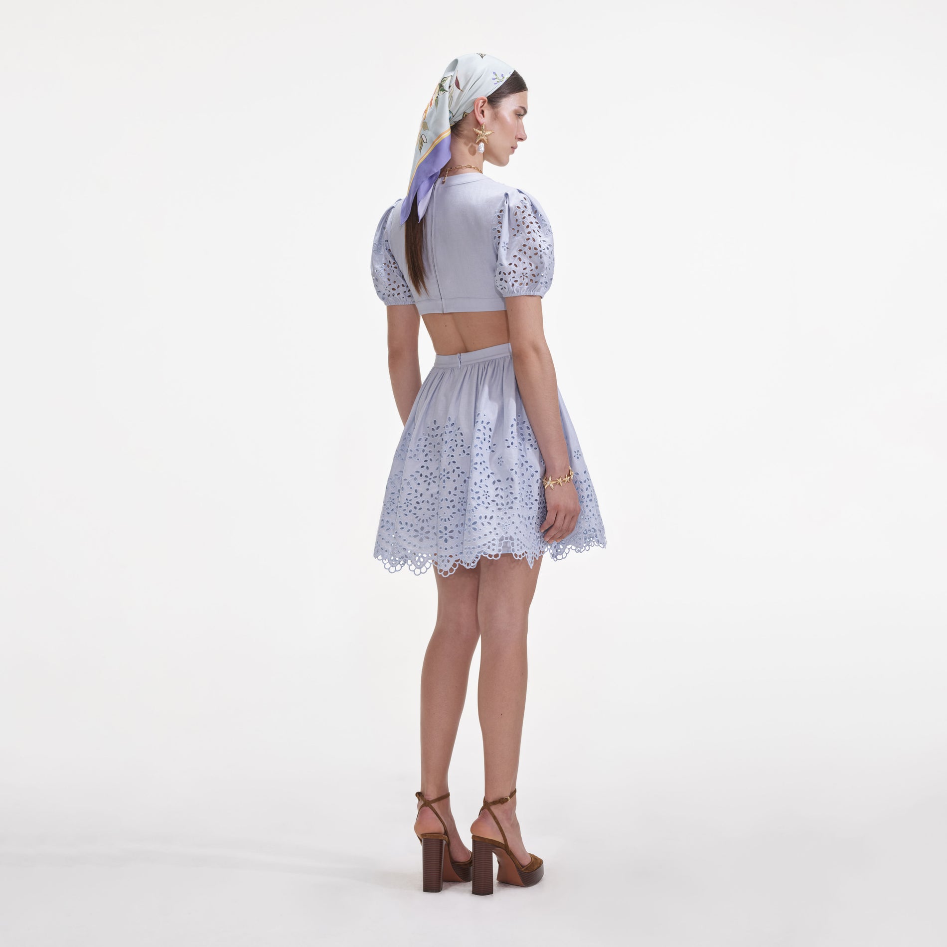 Back view of a woman wearing the Blue Embroidered Linen Mini Dress