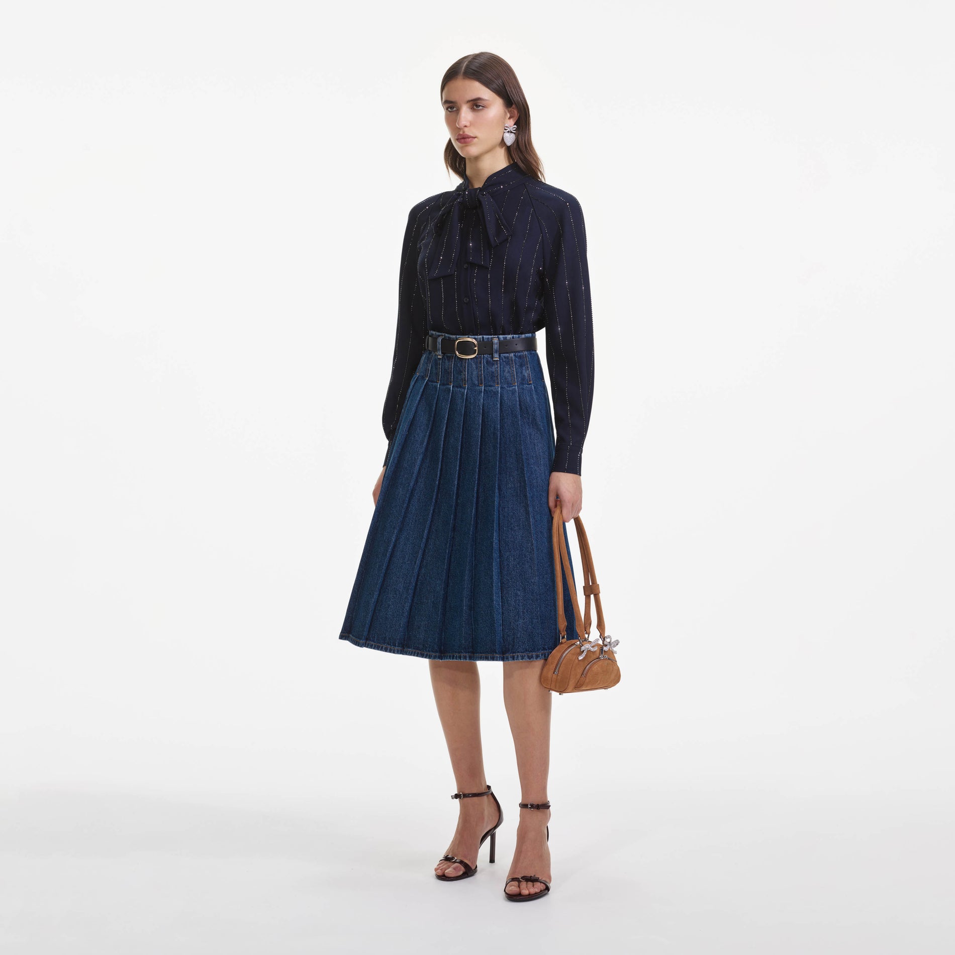 Side view of a woman wearing the Pleated Denim Midi Skirt