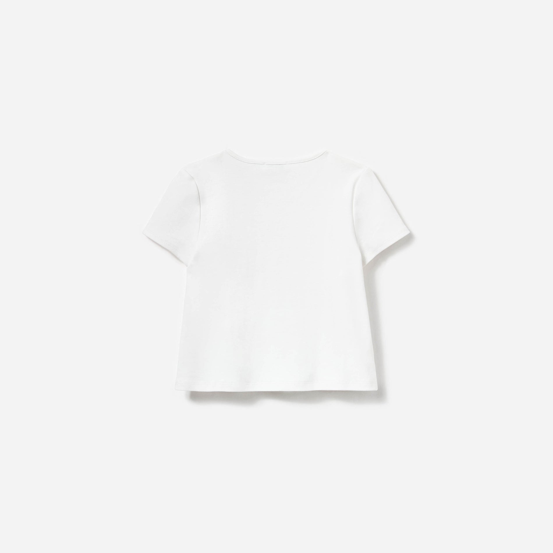 Side view of a woman wearing the Cream Jersey Flower Top