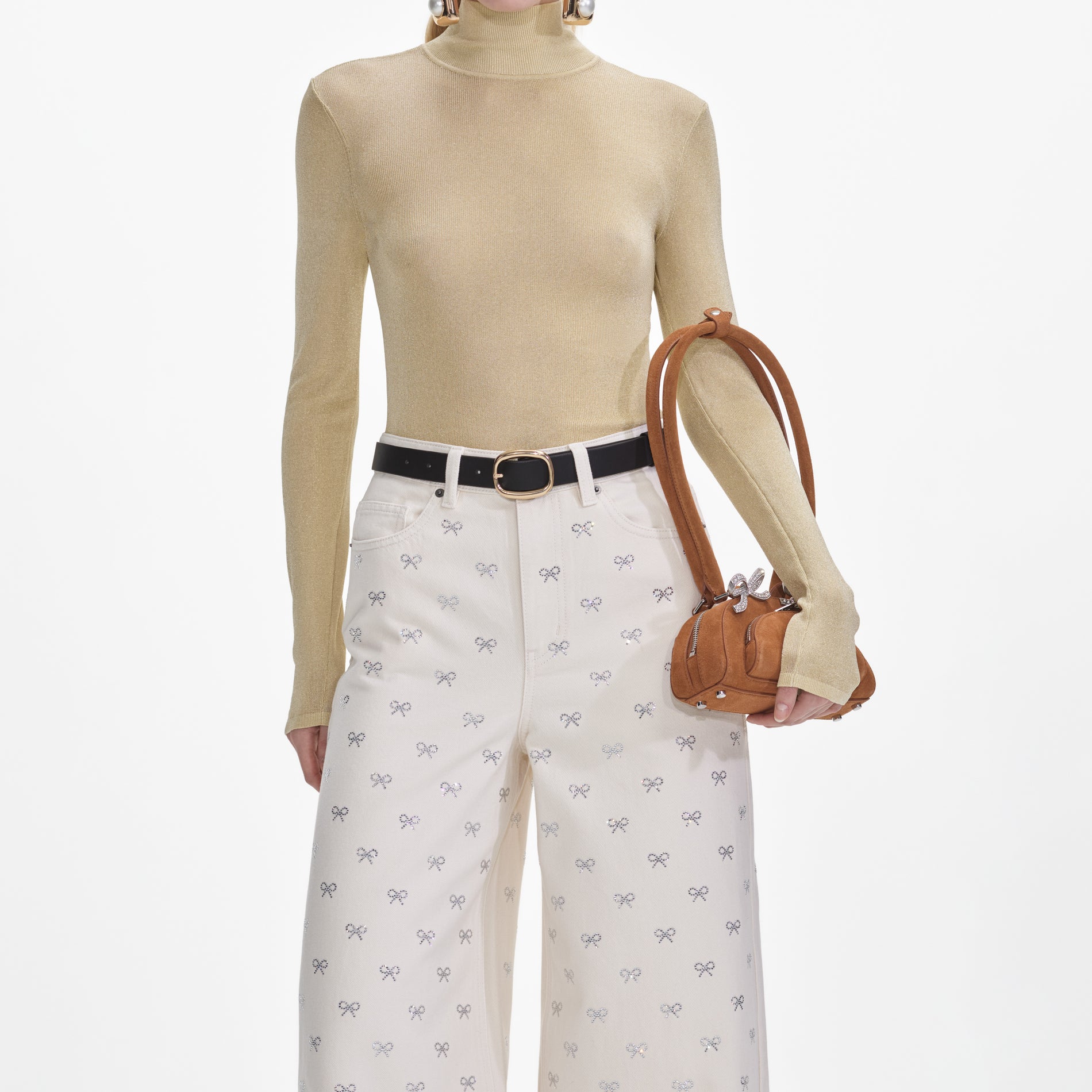 A close up of a woman wearing the Cream Denim Diamante Bow Jeans