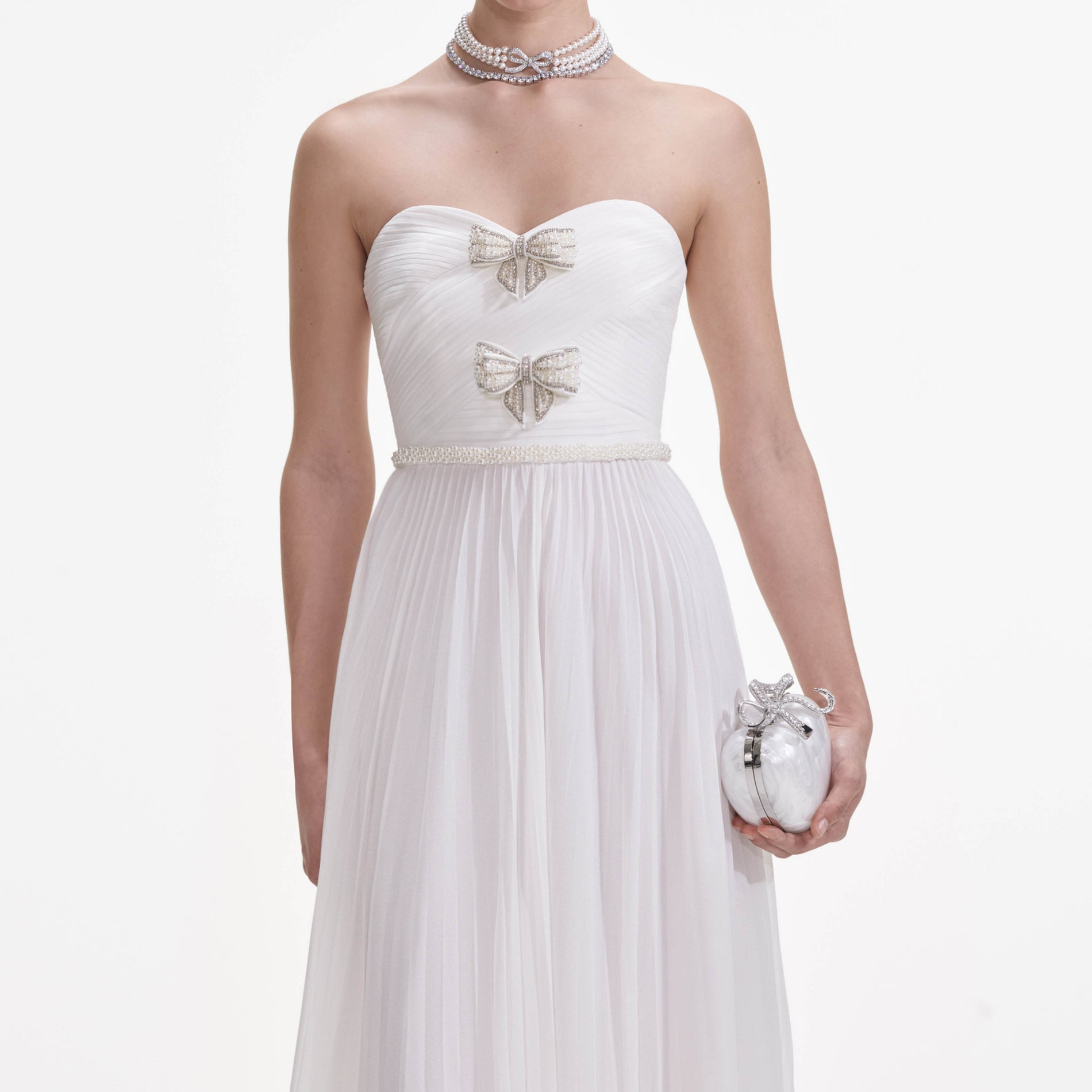 A close up of a woman wearing the White Chiffon Bow Maxi Dress