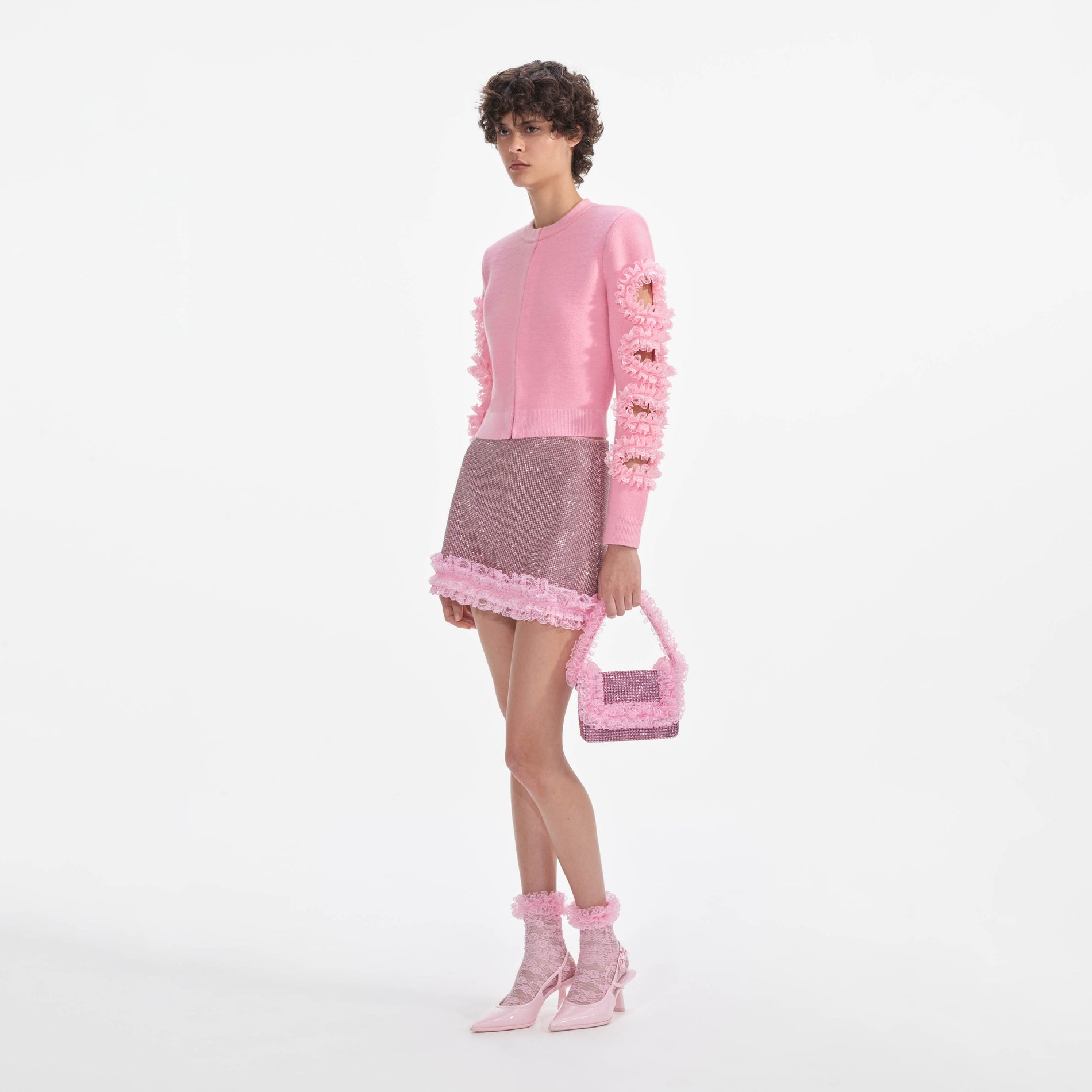 Side view of a woman wearing the Pink Crystal Chainmail Mini Skirt