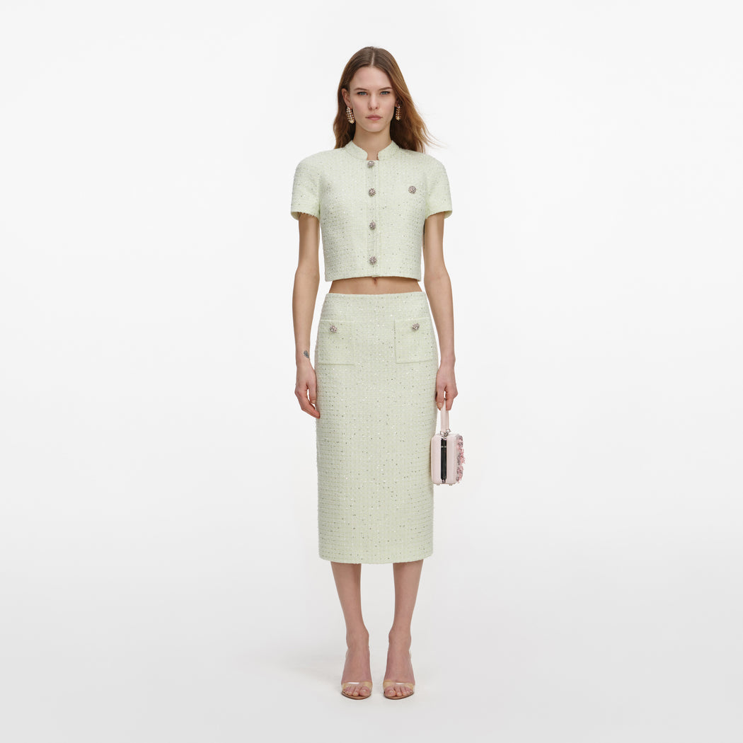 A close up of a woman wearing the Lime Boucle Midi Skirt